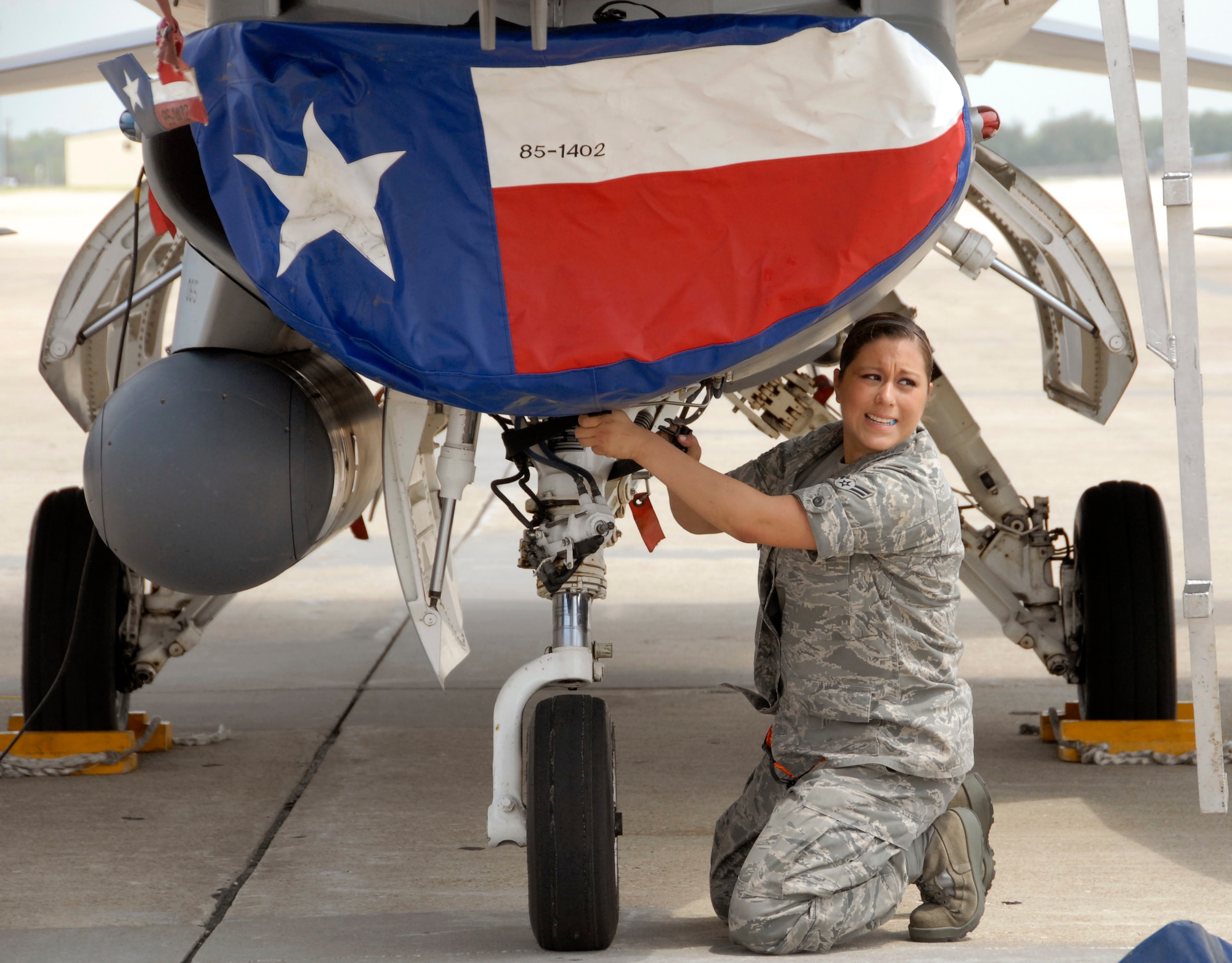 Airman 1st Class Heather Hernandez attaches a cover, embazoned with a stylized Texas state flag, to the intake scoop of an F-16 Fighting Falcon May 13 on the flight-line at Whiteman Air Force Base, Mo.  Airman Hernandez is one of approximately 20 reservists from the 301st Fighter Wing who traveled to Whiteman to assist the 442nd Fighter Wing with an operational-readiness exercise May 14 and 15.  The 442nd FW, an A-10 Thunderbolt II unit based at Whiteman, is preparing for an operational-readiness inspection in October.  Pilots from the 301st FW's 457th Fighter Squadron served as opposing forces, flying training sorties to provide realistic air-to-air threats against the 442nd Fighter Wing's A-10 aircraft.  The 301st FW is based at Naval Air Station, Joint Reserve Base, Fort Worth, Texas.  Airman Hernandez is an F-16 crew chief from the 301st Aircraft Maintenance Squadron.  (U.S. Air Force photo/Maj. David Kurle)