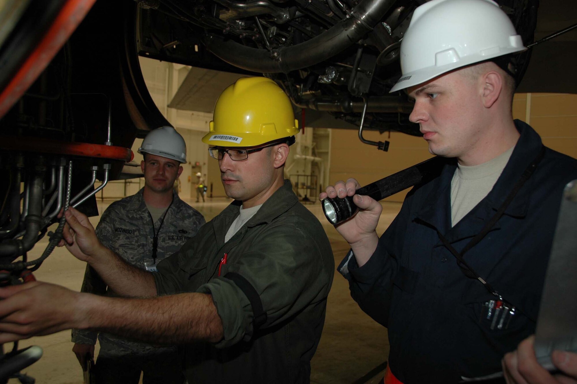 MCGUIRE AIR FORCE BASE, N.J. -- Staff Sgt. Ian Salcedo, center, and Airman 1st Class Scott Johnson, left,  both crew chiefs, check the drain line on a KC-10 Extender while Logistics Standardization and Evaluation Program inspector, Technical Sgt. Donald Mozingo watches during the recent LSEP evaluation held here. (U.S. Air Force photo/Master Sgt. Donna T. Jeffries)