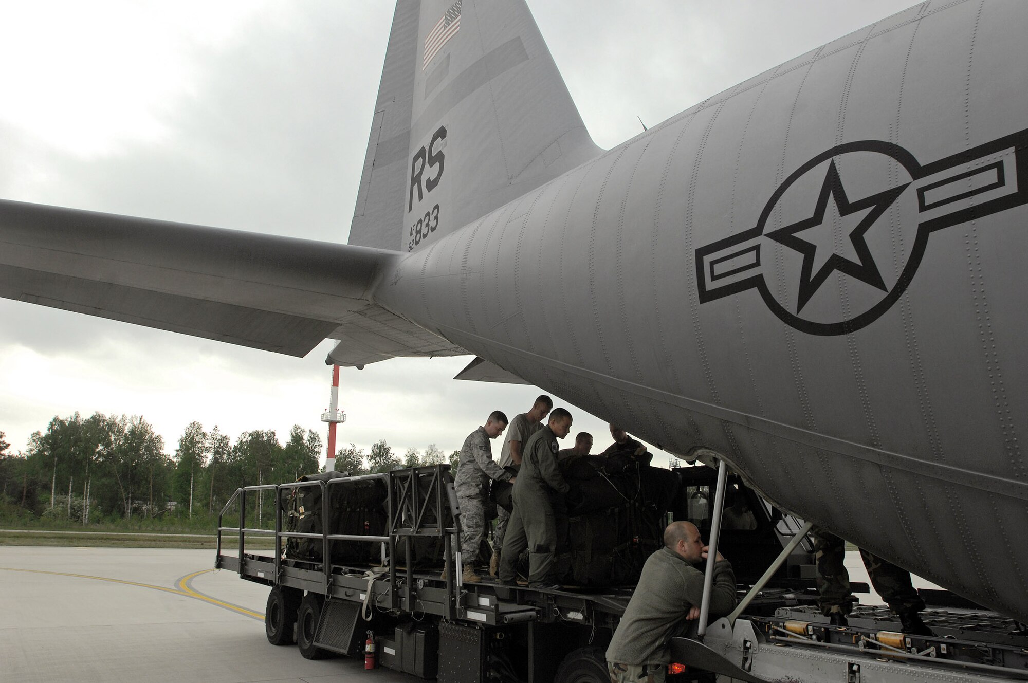 Airmen from the 1st Combat Communication Squadron and 37th Airlift Squadron prepare to load lifesaving equipment onto a C-130 Hercules May 9 at Ramstein Air Base, Germany. The Airmen supported NASA's launch of Space Shuttle Atlantis May 11. (U.S. Air Force photo/Senior Airman Kenny Holston)