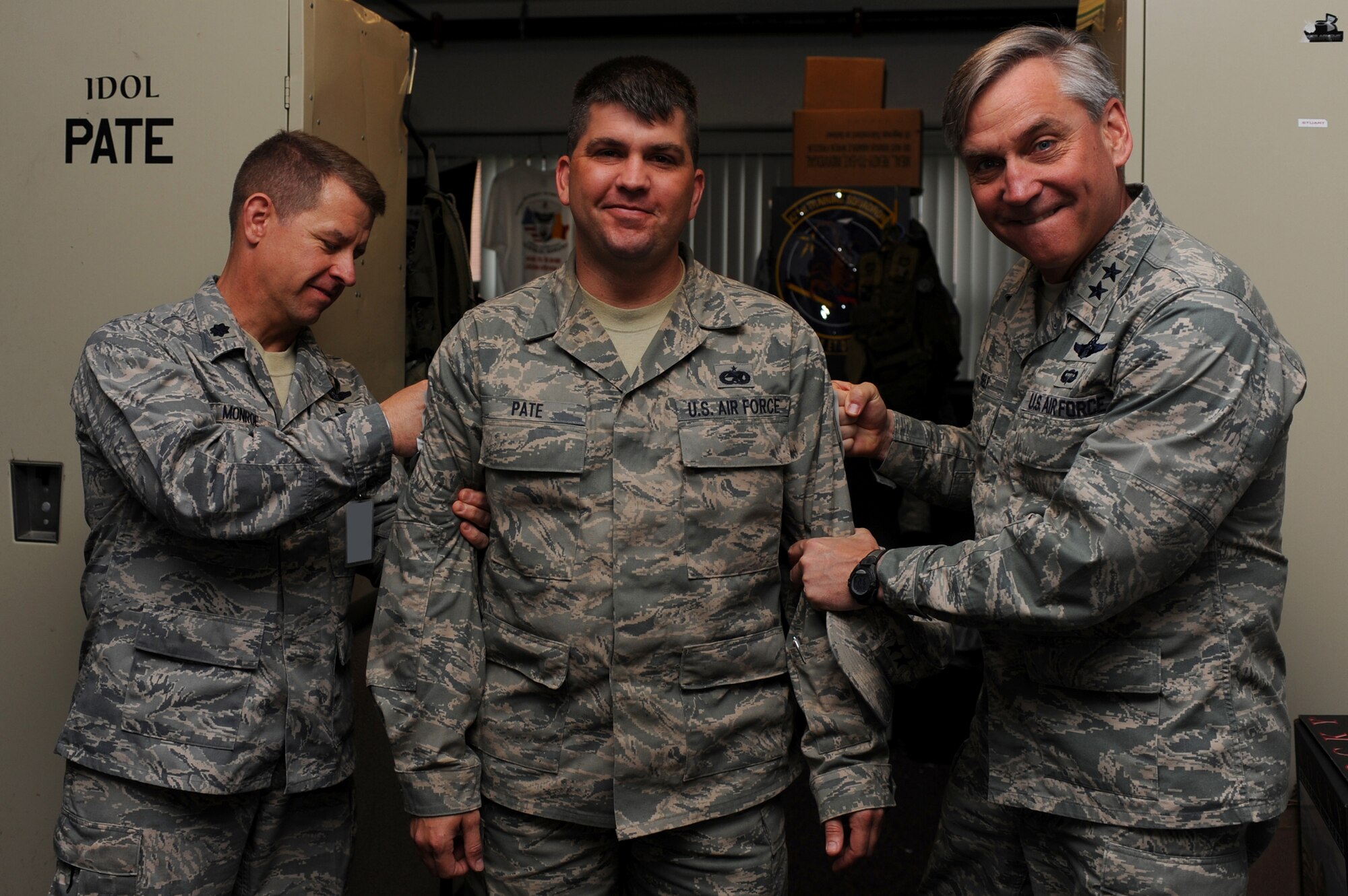 Major Gen. Kip Self, U.S. Air Force Expeditionary Center commander, and Lt. Col. Mitchell Monroe, 421st Combat Training Squadron commander, tack master sergeant stripes on Tech Sgt. Jesse Pate Jr., also with the 421st CTS, on May 14 at the center.  Ten Airmen from the Expeditionary Center were selected for E-7 stripes. (U.S. Air Force Photo/Staff Sgt. Nathan G. Bevier) 