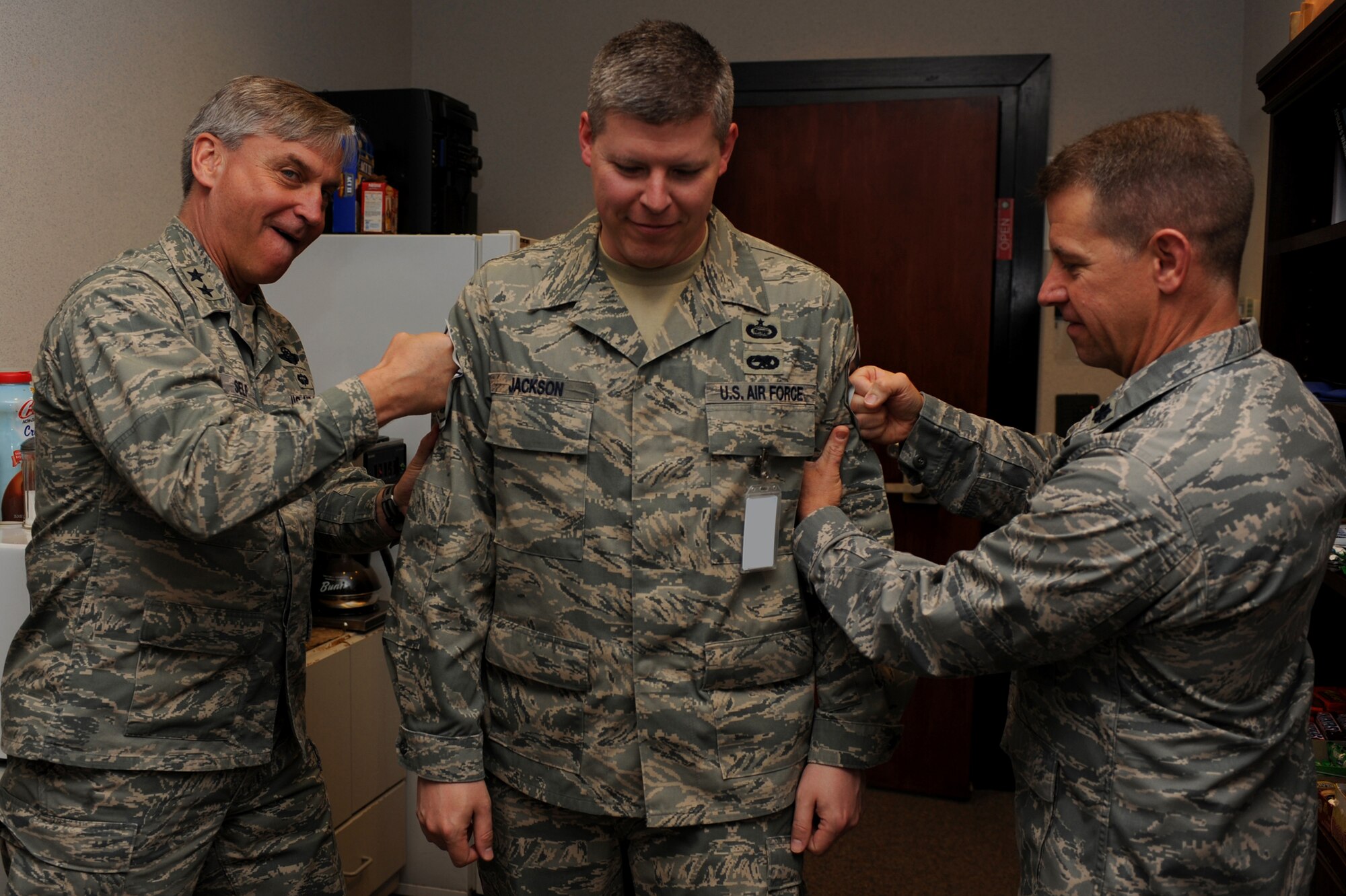 Major Gen. Kip Self, U.S. Air Force Expeditionary Center commander, and Lt. Col. Mitchell Monroe, 421st Combat Training Squadron commander, tack master sergeant stripes on Tech Sgt. Scott Jackson, also with the 421st CTS, on May 14 at the center.  Ten Airmen from the Expeditionary Center were selected for E-7 stripes. (U.S. Air Force Photo/Staff Sgt. Nathan G. Bevier) 
