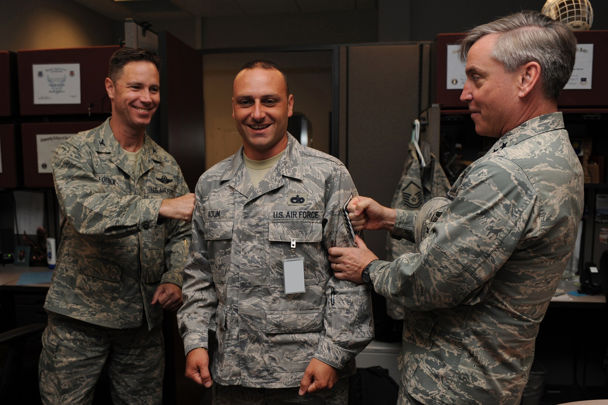 Major Gen. Kip Self, U.S. Air Force Expeditionary Center commander, and Col. Mark Loeben, Expeditionary Center acting vice commander, tack master sergeant stripes on Tech Sgt. Jad Aoun, with the Mobility Operations School, on May 14 at the center.  Ten Airmen from the Expeditionary Center were selected for E-7 stripes. (U.S. Air Force Photo/Staff Sgt. Nathan G. Bevier) 