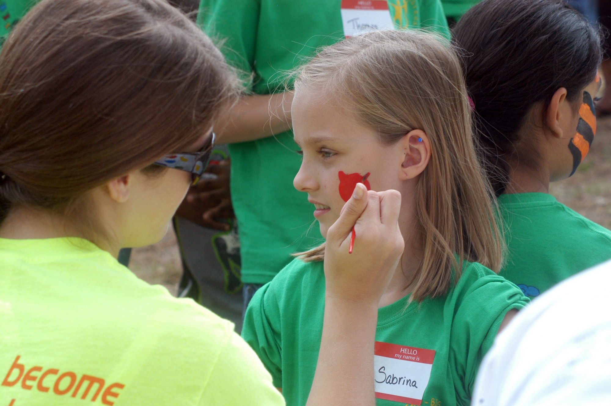 Sabrina Preskitt, 4th grade student at Lindsey Elementary, has a cat painted on her face at the REACH picnic at Robins Park April 30. U. S. Air Force photo by Sue Sapp