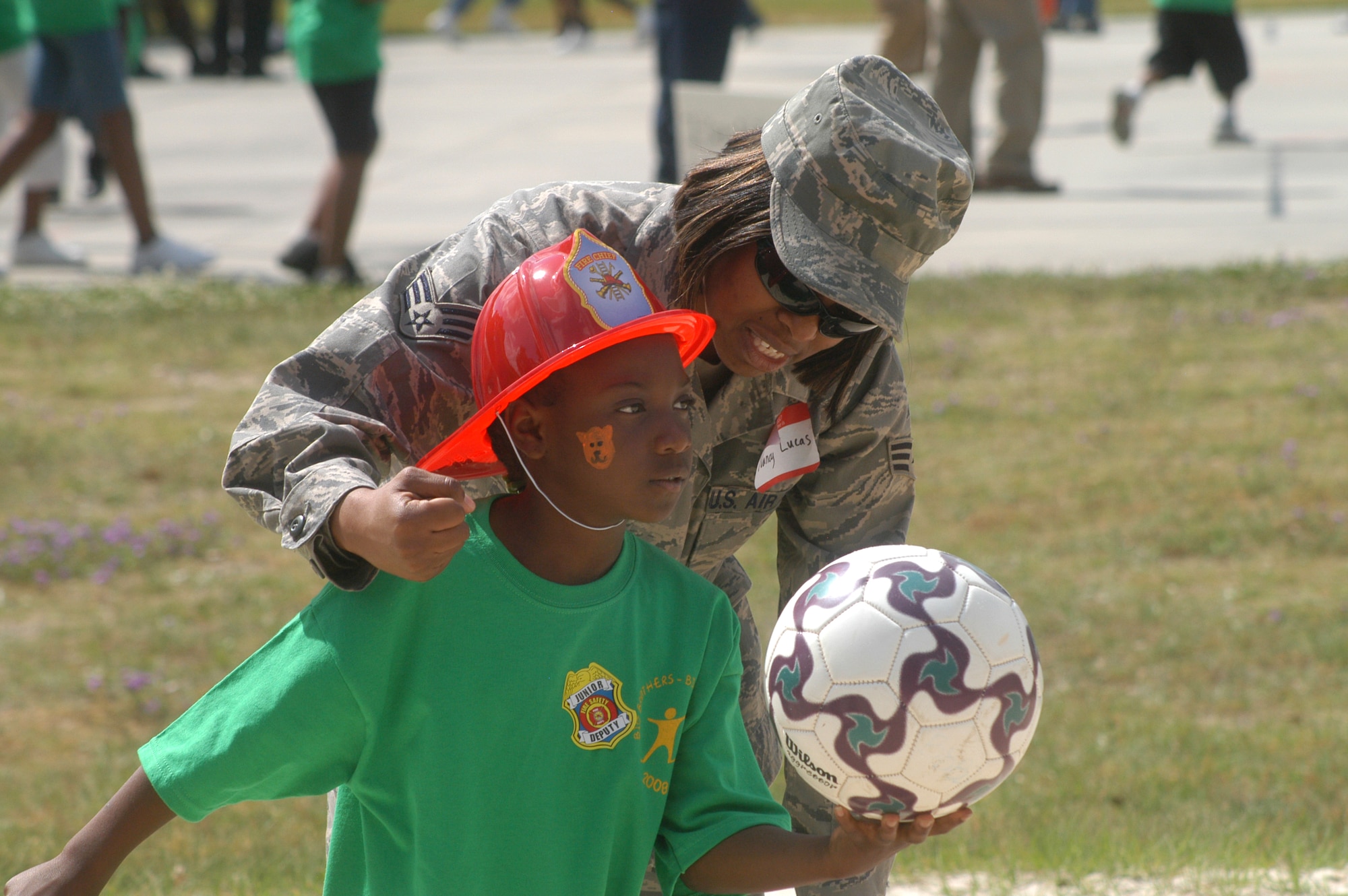 SrA Nancy Lucas teaches Yolanda Gibson, 8, how to serve a volleyball at the REACH picnic at Robins Park April 30. U. S. Air Force photo by Sue Sapp  