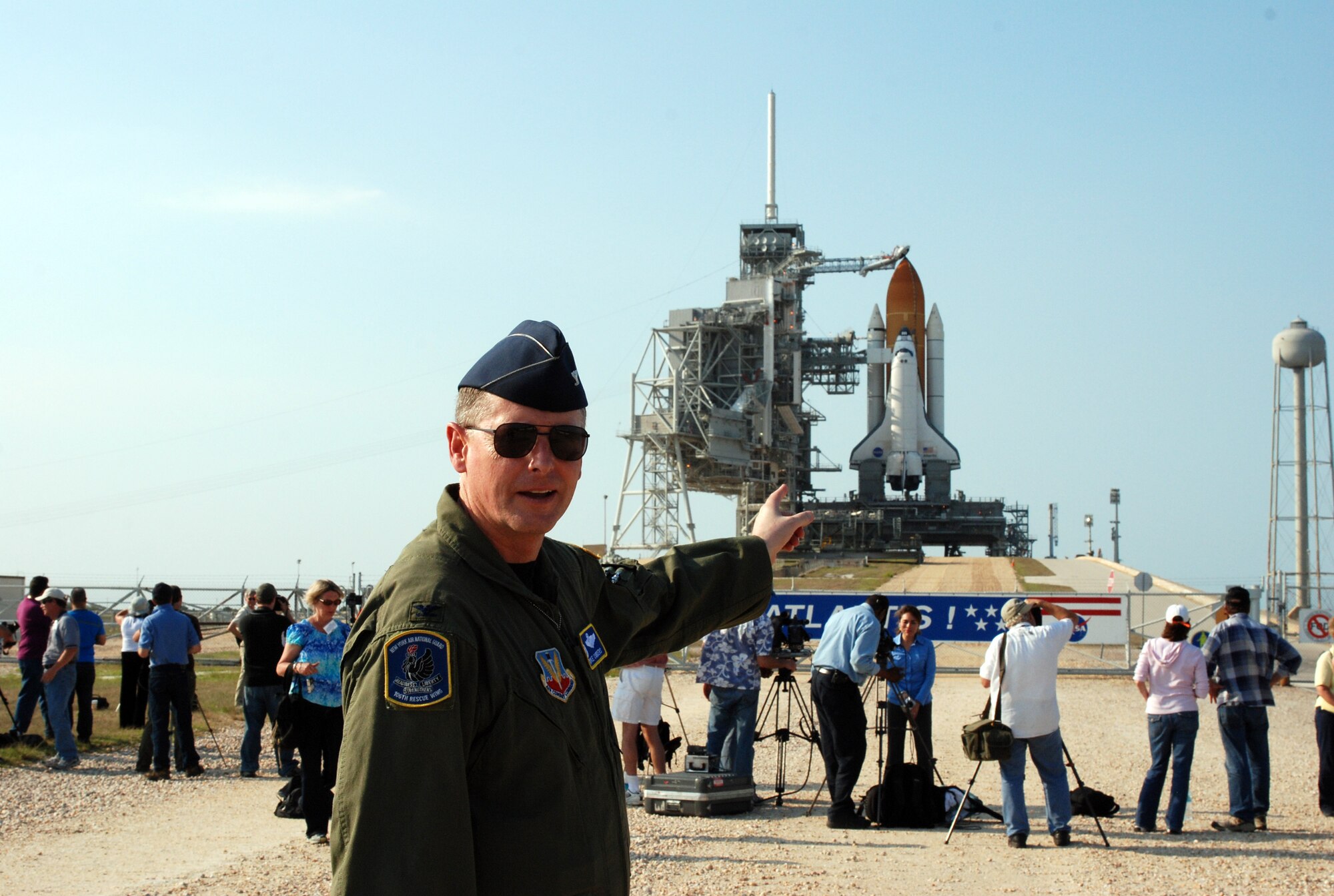 Col. Michael Canders, commander of the New York Air National Guard’s 106th Rescue Wing, based at Westhampton Beach, explains how NASA astronauts would bail out of the Atlantis Space Shuttle (background) if a parachute descent to safety was required, known as a Mode 8 Emergency Egress. On May 11, 2009, the 106th Rescue Wing participated in its 100th mission in support of NASA’s Space Shuttle launch program at Kennedy Space Center, Cape Canaveral, Fla. (Photo by Master Sgt. Corine Lombardo, New York National Guard)