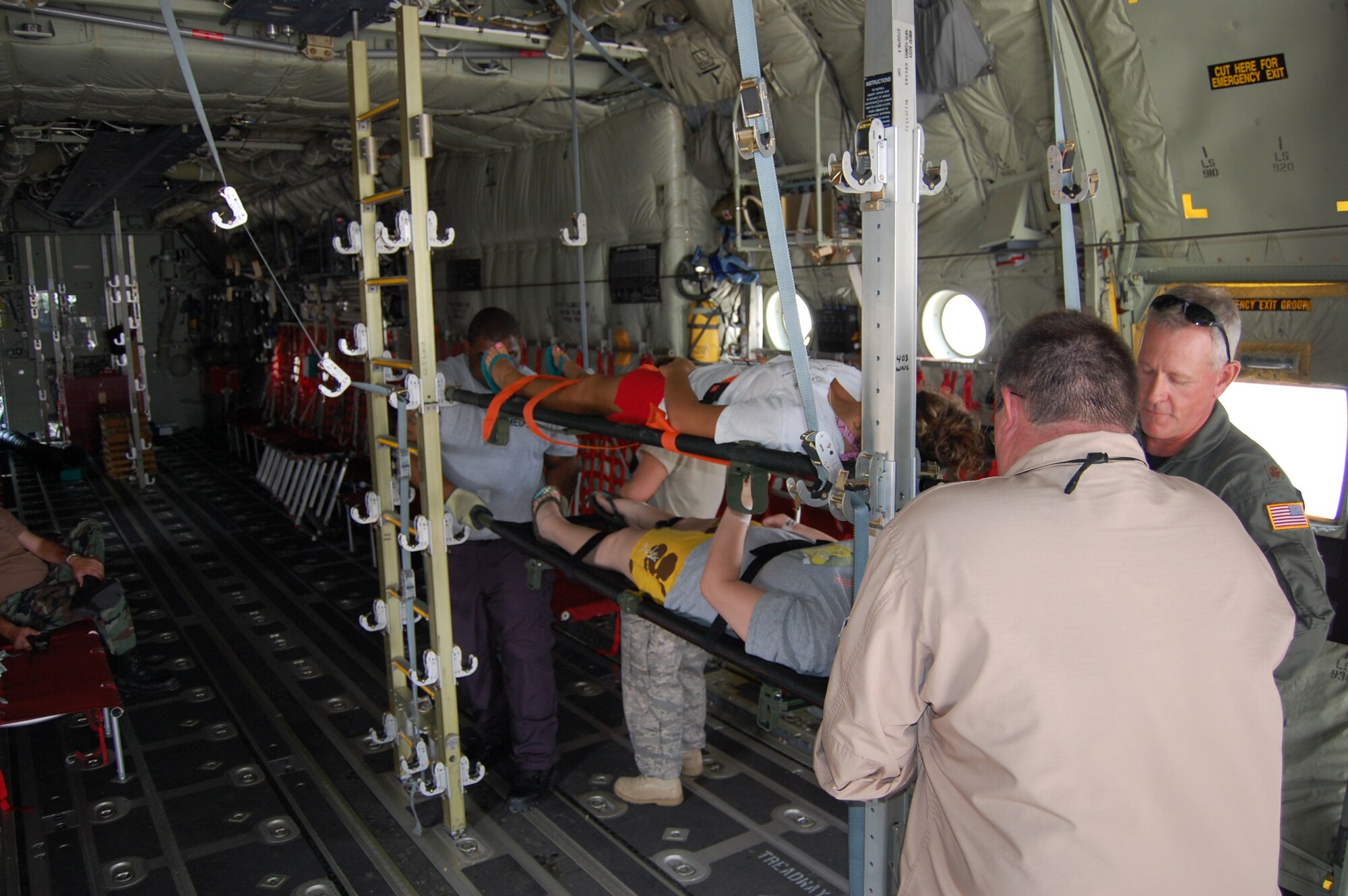 Maj. Kerry Hesselrode, right, 81st Inpatient Operations Squadron, secures a “patient” aboard an 815th Airlift Squadron C-130J Hercules on the Keesler flight line May 7 during the Lifesaver 2009 exercise.  (U.S. Air Force photo by Steve Pivnick)