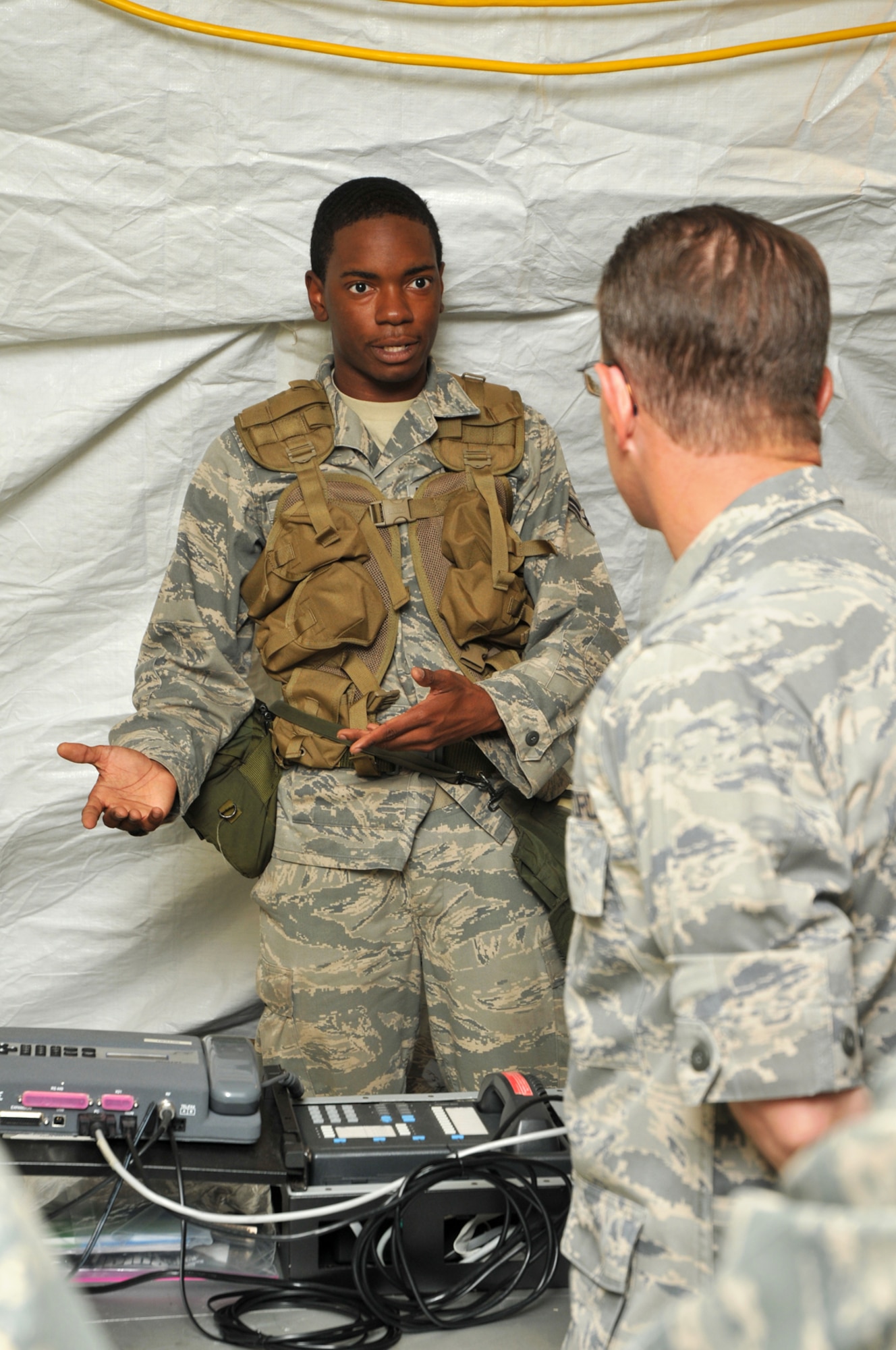 Airman 1st Class Jeffrey Bellin, left, 54th CBCS, explains the communications equipment used in the deployment exercise to Col. Christopher Valle, 81st Training Wing commander.  (U.S. Air Force photo by Adam Bond)