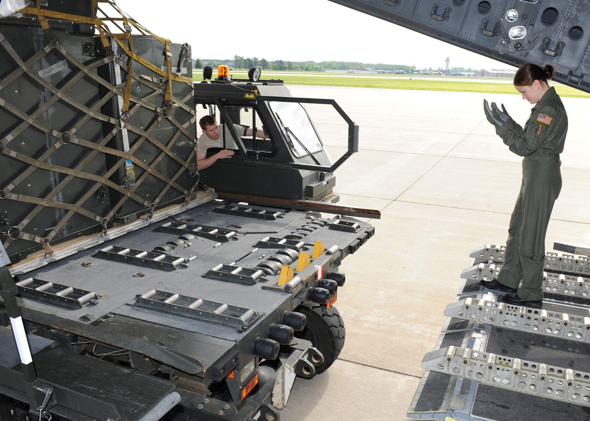 SCOTT AIR FORCE BASE, Ill. -- Airman 1st Class Samantha Earnest, loadmaster with the 6th Airlift Squadron at McGuire Air Force Base, N.J., guides a pallet laden K-Loader to the back of a C-17 Globemaster III at Scott Air Force Base, Ill., May 12. The cargo will be flown to Volk Field, Wisc., where 375th Airlift Wing Airmen will train with the Minnesota Air National Guard 133rd Airlift Wing and the 94th Arial Port Squadron (Reserve) from Robins Air Force Base, Ga. in preparation for the wing's for the operational readiness inspection in March 2010.  Senior Airman Keith Wilcox, 375th Logistics Readiness Squadron passenger services representative, is the driver of the K-Loader. (U.S. Air Force photo/Staff Sgt. Paul Villanueva II)