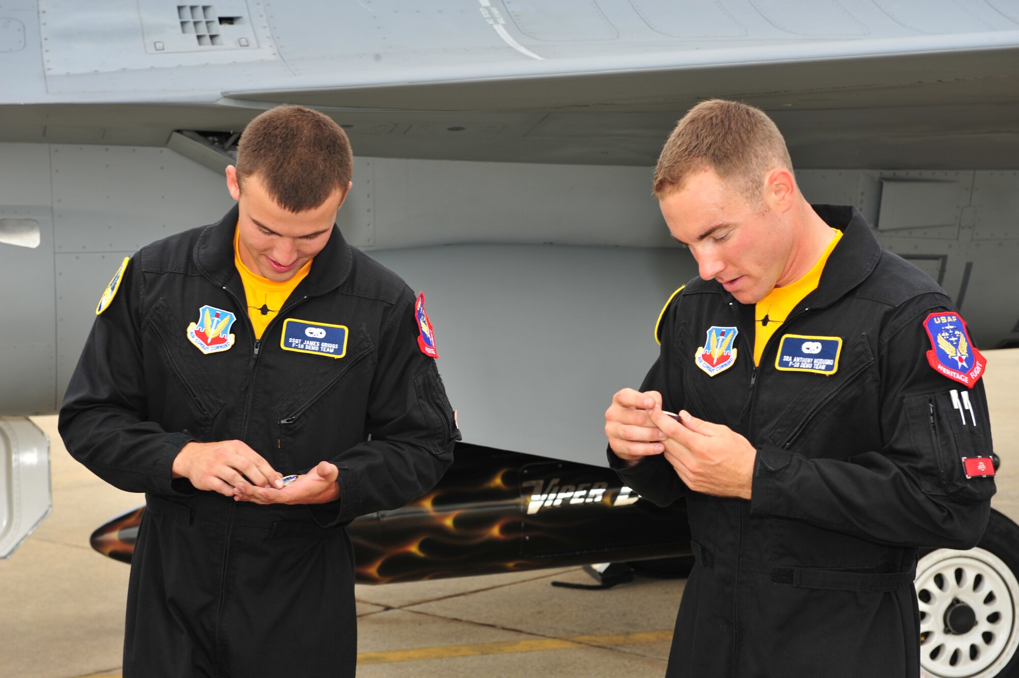 SHAW AIR FORCE BASE, S.C.- Senior Airman Anthony J. Modugno, and Staff Sergeant James A. Griggs both dedicated crew chiefs of the Viper East F-16 Demonstration Team, examine coins presented to them by Colonel Robert A. Hopkins Jr, Commander of the 20th Maintenance Group. The pair were recognized by Col Hopkins for volunteering their personal time refinishing a travel pod over a two week period to bring it up to show standards, 14 May 2009. (U.S. Air Force Photo by: TSgt Josef Cole)
 

