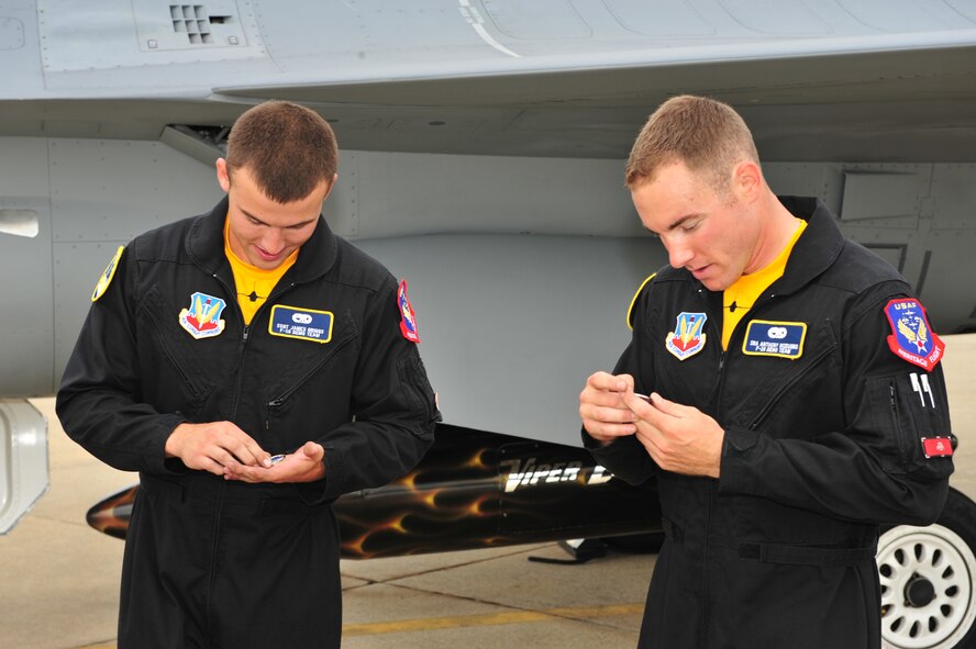 SHAW AIR FORCE BASE, S.C.- Senior Airman Anthony J. Modugno, and Staff Sergeant James A. Griggs, both dedicated crew chiefs of the Viper East F-16 Demonstration Team, examine coins presented to them by Colonel Robert A. Hopkins Jr., 20th Maintenance Group commander. The pair were recognized by Colonel Hopkins for volunteering their personal time refinishing a travel pod over a two-week period to bring it up to show standards, May 14, 2009. (U.S. Air Force Photo by: Tech. Sgt. Josef Cole) 

