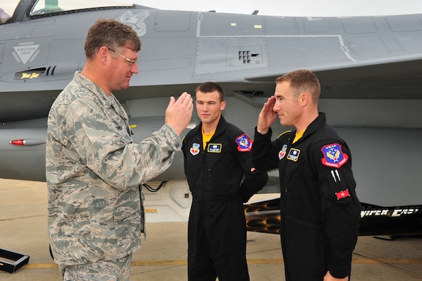 SHAW AIR FORCE BASE, S.C.- Col. Robert A. Hopkins Jr., 20th Maintenance Group commander, returns the salute of Senior Airman Anthony J. Modugno, as Staff Sergeant James A. Griggs watches. Both Airmen are dedicated crew chiefs on the Viper East F-16 Demonstration Team. The pair was recognized by Colonel Hopkins for volunteering their personal time refinishing a travel pod over a two-week period to bring it up to show standards, May 14, 2009. (U.S. Air Force Photo by: Tech. Sgt. Josef Cole) 

