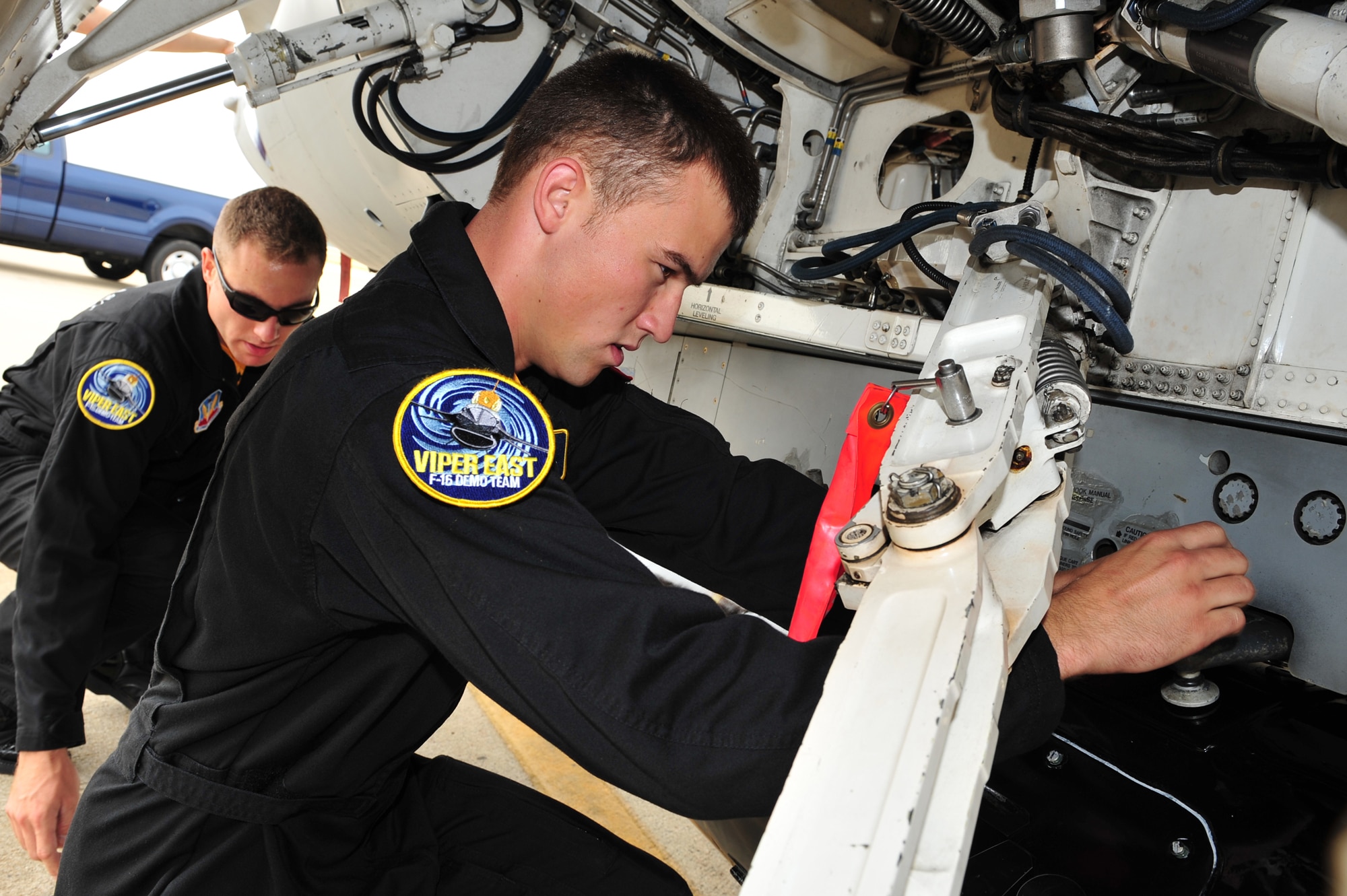 SHAW AIR FORCE BASE, S.C.- Senior Airman Anthony J. Modugno, background, and Staff Sergeant James A. Griggs, both dedicated crew chiefs of the Viper East F-16 Demonstration Team hang a travel pod onto their F-16. The pair volunteered their personal time refinishing the pod over a two week period to bring it up to show standards, 14 May 2009. (U.S. Air Force Photo by: TSgt Josef Cole)
 
