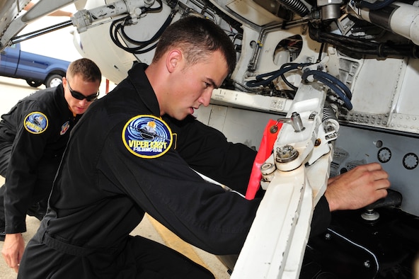 SHAW AIR FORCE BASE, S.C.- Senior Airman Anthony J. Modugno, background, and Staff Sergeant James A. Griggs, both dedicated crew chiefs of the Viper East F-16 Demonstration Team, hang a travel pod onto their F-16. The pair volunteered their personal time refinishing the pod over a two-week period to bring it up to show standards, May 14, 2009. (U.S. Air Force Photo by: Tech. Sgt. Josef Cole) 


