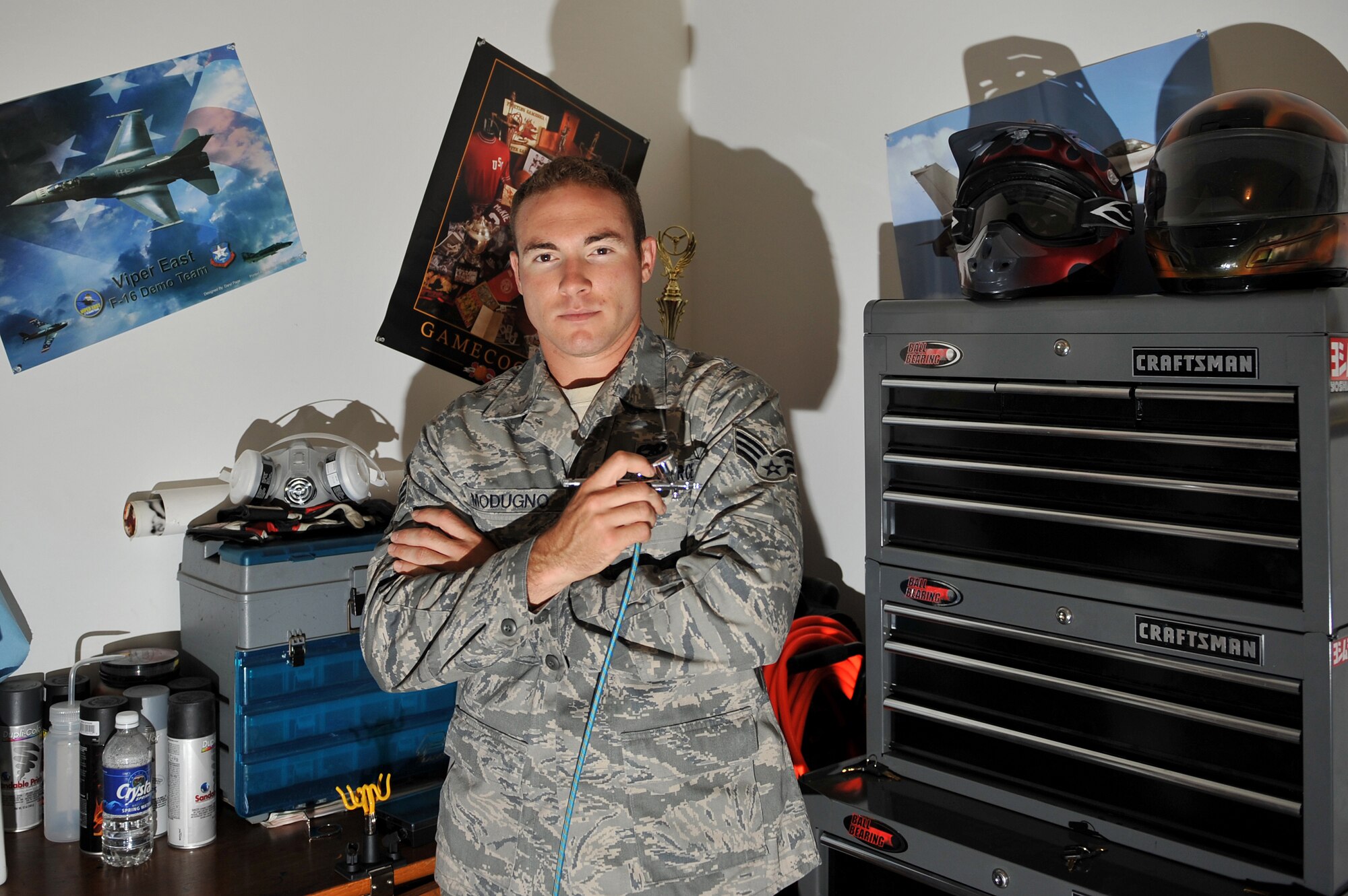 SHAW AIR FORCE BASE, S.C.-- Senior Airman Anthony J. Modugno, a Viper East F-16 Demonstration Team member and dedicated crew chief showcases one of the tools of his other trade as an airbrush artist. SrA Modugno along with demo team member Staff Sergeant James A. Griggs refinished an areial storage compartment called a travel pod to better show case the demo team's F-16 demonstrator, 11 May 2009. (US Air Force Photo By: TSgt Josef Cole)