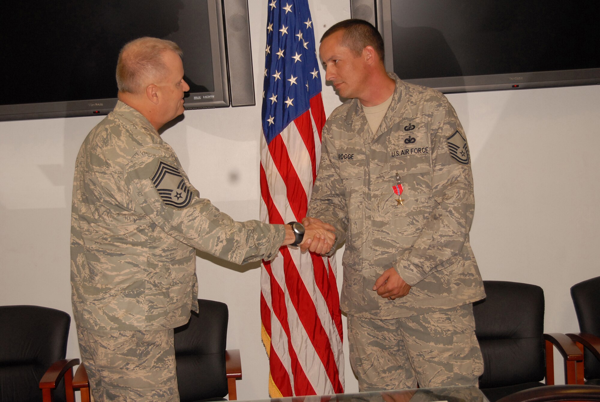 Chief Master Sgt. Phillip Poole, acting 43rd Airlift Wing Command Chief, congratulates Master Sgt. Scott Rogge, 43rd Contracting Squadron, for receiving the Bronze Star in a ceremony at the 43rd CONS conference room May 6. (U.S. Air Force Photo by Airman 1st Class Mindy Bloem)