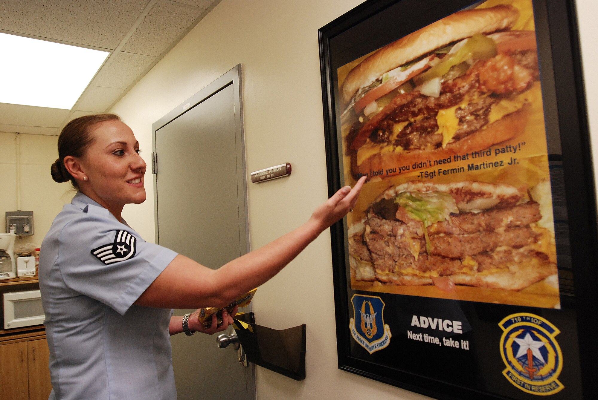Staff Sergeant Amanda Stephens, a knowledge operations manager for the 710th Information Operations Flight, a Reserve unit at Brooks City-Base, Texas, shows off a motivational poster she made based on a conversation bewteen two co-workers over a cheeseburger. The 433rd Airlift Wing provides medical support and mission-essential training for the 710th IOF and Sergeant Stephens is the one who keeps  her unit organized and ready. Sergeant Stephens has the task of keeping her flight deployment-ready at any given time but she finds time to make posters like this, which adorn the walls of the office. (U.S. Air Force Photo/Airman Brian McGloin)