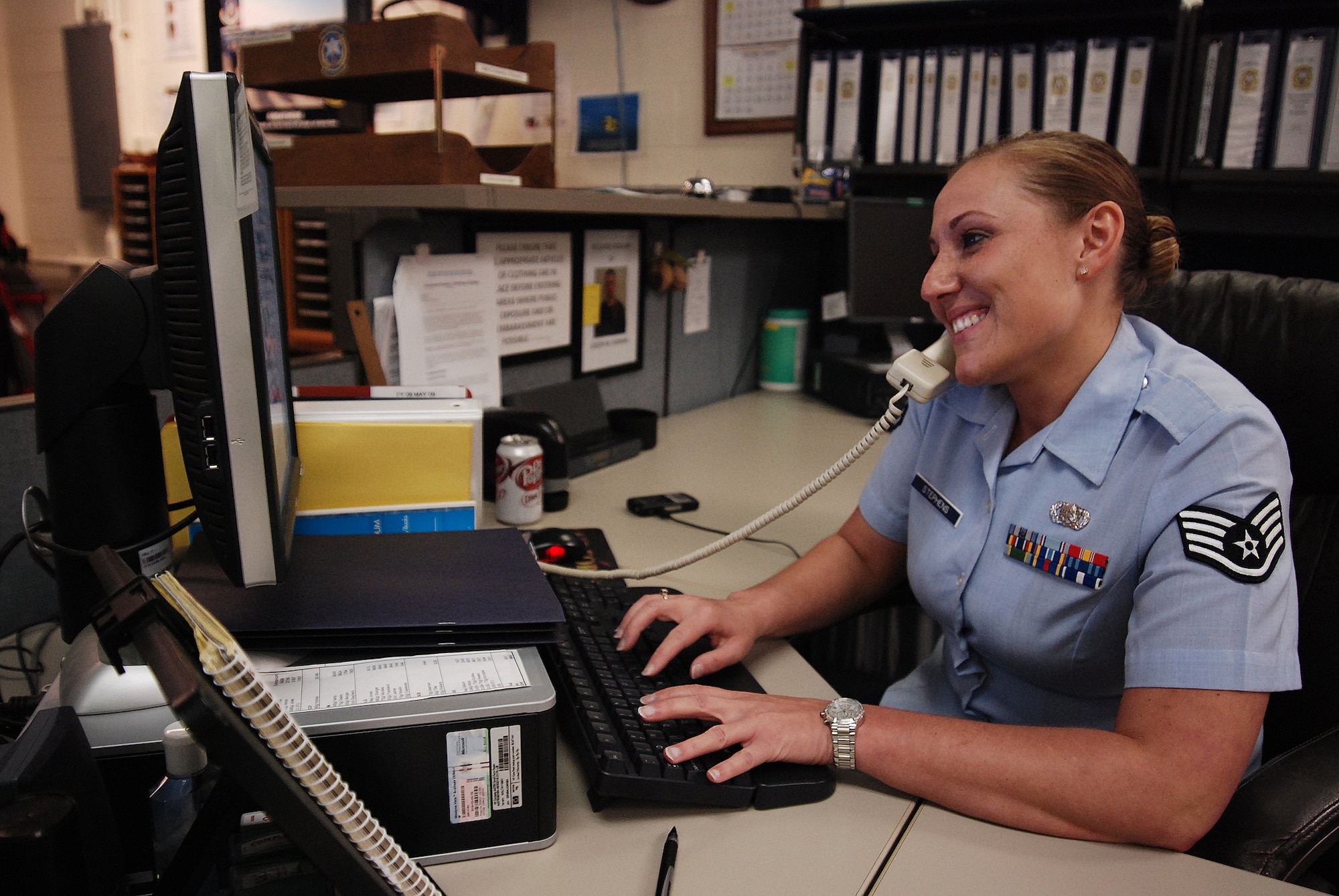 Staff Sergeant Amanda Stephens, a knowledge operations manager for the 710th Information Operations Flight, a Reserve unit at Brooks City-Base, Texas, smiles as she takes a phone call. The 433rd Airlift Wing provides medical support and mission-essential training for the 710th IOF and Sergeant Stephens is the one who keeps her unit organized and ready. Sergeant Stephens is known for her positive attitude while working, (U.S. Air Force Photo/Airman Brian McGloin)
