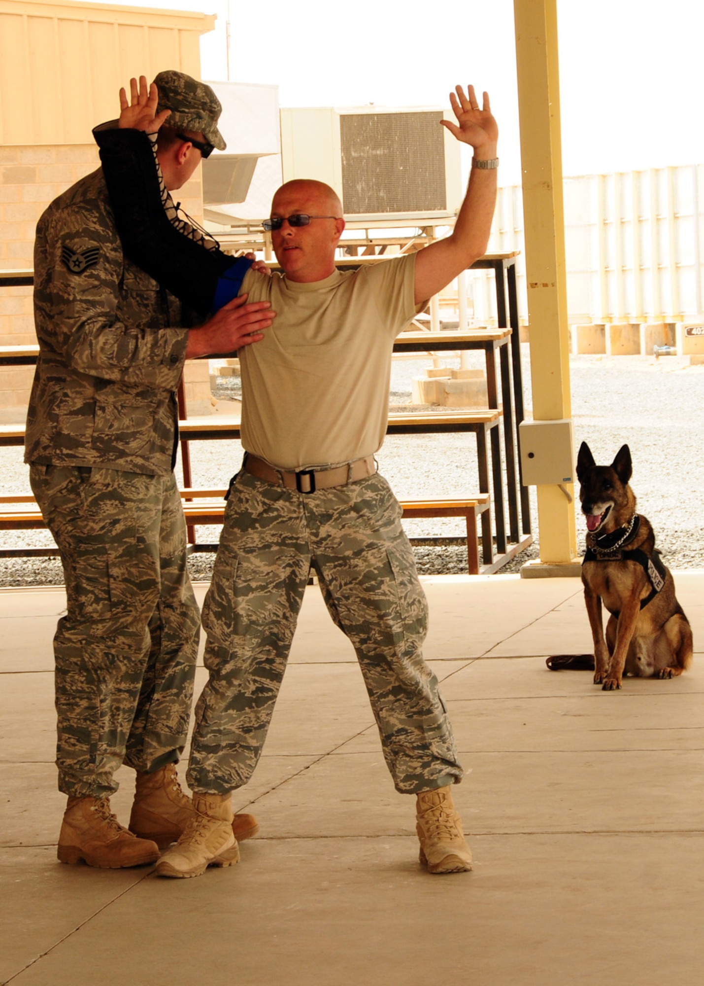 SOUTHWEST ASIA -- Security Forces members from the 386th Expeditionary Security Forces Squadron demonstrates the search and re-attacks method for the K-9 Demonstration during Police Week at an air base in Southwest Asia, May 11. The search and re-attack method consist of the handler searching the suspect, and when the suspect attempts to harm the handler, the dog attacks without command. (U.S. Air Force photo/ Senior Airman Courtney Richardson)