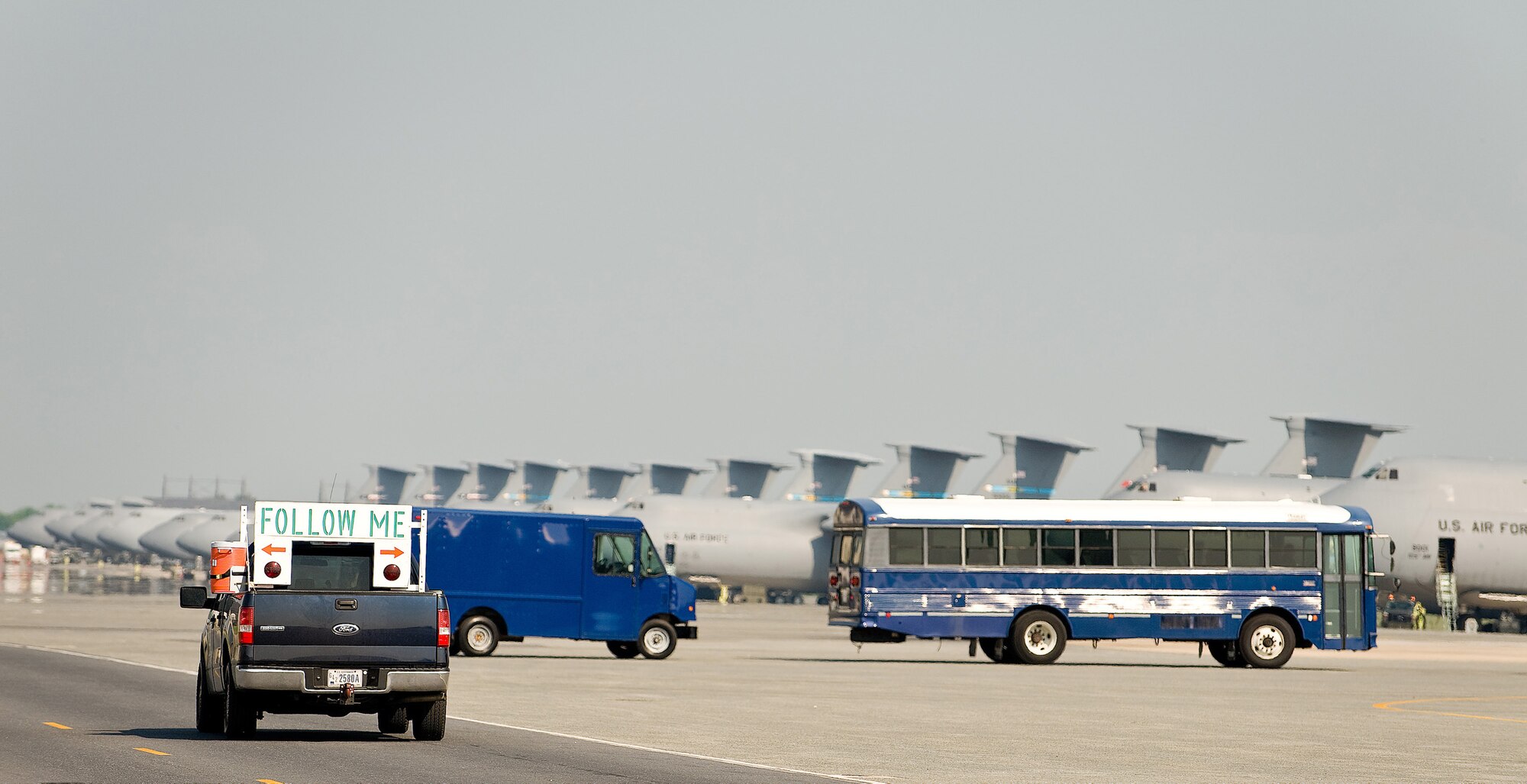 (RELEASED) A follow-me truck departs after successfully leading a transient aircraft to an assigned parking spot at Dover Air Force Base May 12. The follow-me truck is the symbol of the 436th Aircraft Maintenance Squadron Transient Maintenance Flight, which is responsible for recovering, servicing and launching aircraft at Dover AFB that are not assigned to Dover.(U.S. Air Force Photo/Roland Balik)