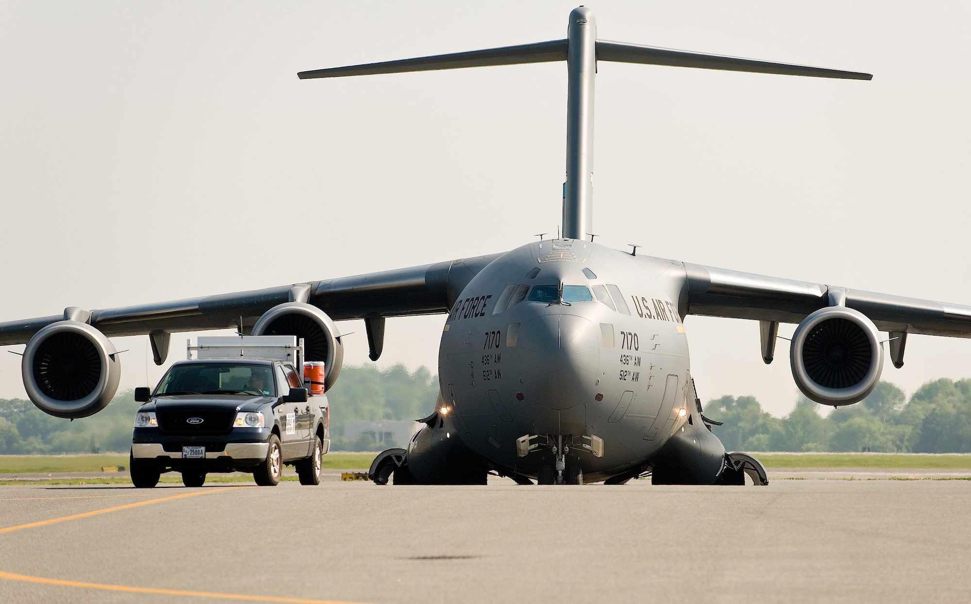 (RELEASED) A 436th Aircraft Maintenance Squadron Transient Maintenance Flight member guides a C-17 Globemaster III to an assigned parking spot at Dover Air Force Base May 12. The follow-me truck, the most recognizable symbol of the Transient Maintenance Flight, is used to direct non-Dover assigned aircraft to various parking spaces so that Transient Maintenance can service and launch the aircraft. (U.S. Air Force photo/Roland Balik)