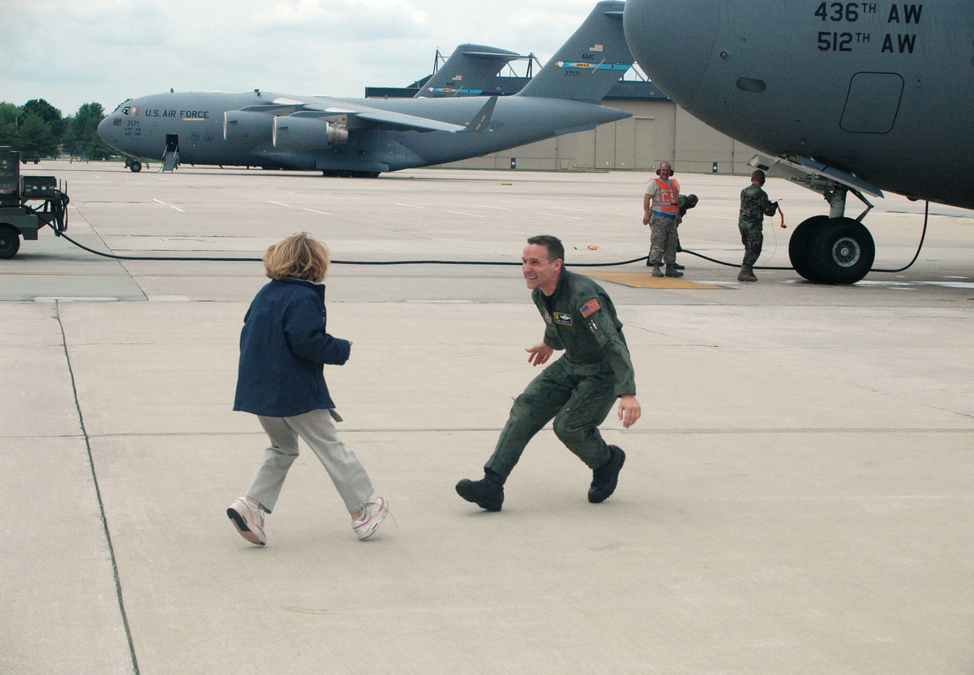 Seconds after Col. Robert Shepherd was doused with water from both a cooler of water and two firetrucks, he ran to embrace his daughter Allison, who was waiting on the ground to witness her dad's final C-17 flight here. Colonel Shepherd, a special assistant to the 512th Airlift Wing commander, is moving to Maxwell Air Force Base, Ala. (U.S. Air Force photo/Capt. Jason Pennypacker)