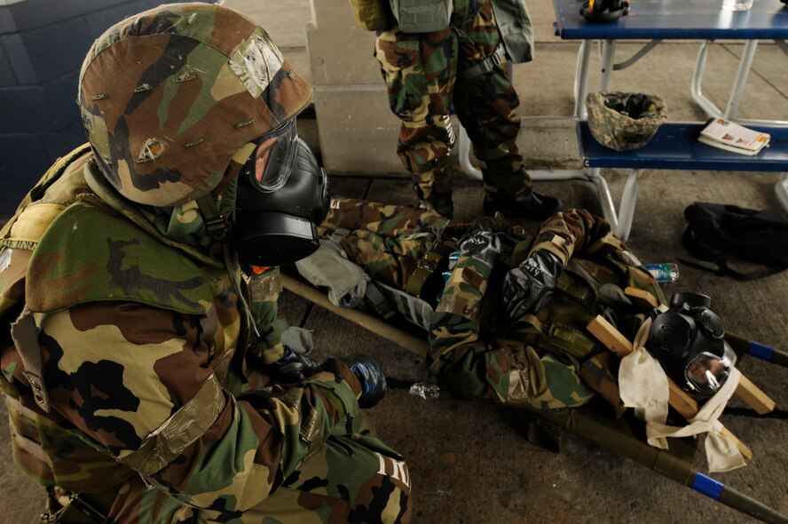 Airman 1st Class Jeffrey Melnik, 18th Aircraft Maintenance Squadron, treats a simulated casualty during a training scenario of the Beverly High 09-2 Local Operational Readiness Exercise May 14. The LORE tests base personnel on their combat readiness for real world emergency/combat  events. (U.S. Air Force photo/Airman 1st Class Chad Warren)