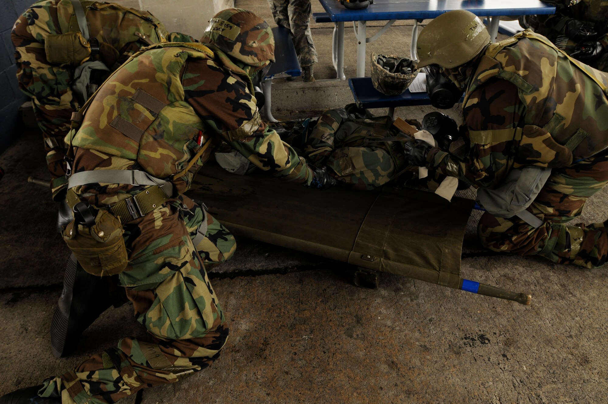 Airmen assigned to the 18th Aircraft Maintenance Squadron lift a simulated casualty onto a litter during a training scenario of the Beverly High 09-2 Local Operational Readiness Exercise May 14. The LORE tests base personnel on their combat readiness for real world emergency/combat  events. (U.S. Air Force photo/Airman 1st Class Chad Warren)