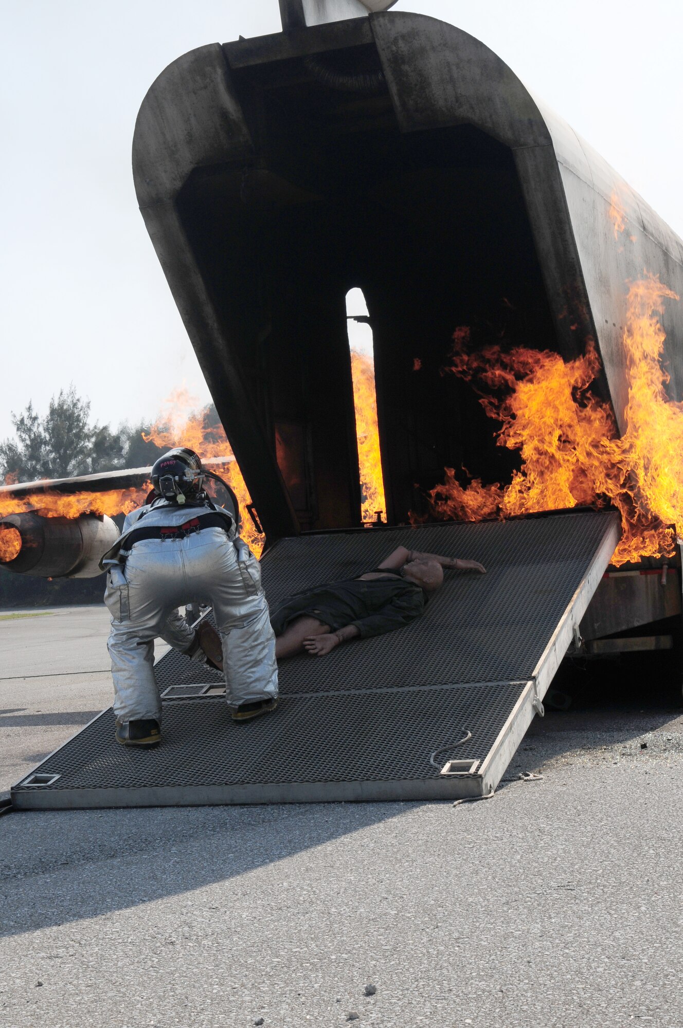 A fire fighter from the 18th Civil Engineer Squadron, simulates the rescue of an air crew member during a  live-fire inject as part of the Beverly High 09-2 Local Operational Readiness Exercise May 14. The LORE tests base personnel on their combat readiness for real world emergency/combat  events. (U.S. Air Force photo/Staff Sgt. Lakisha A. Croley )