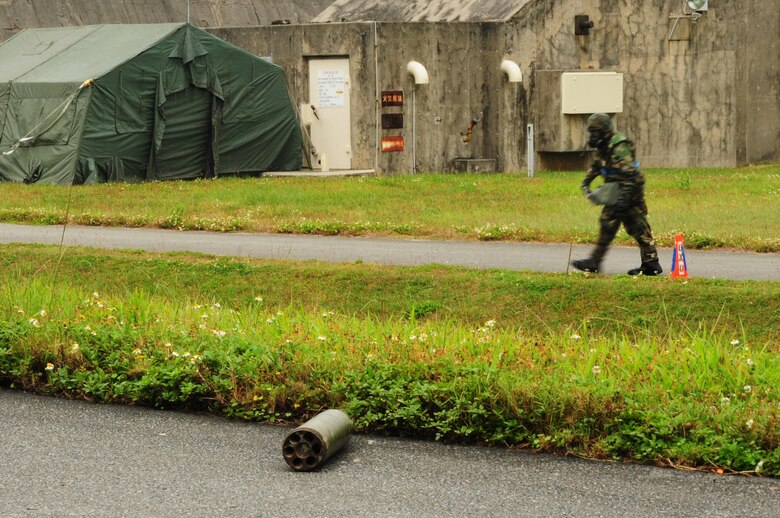 After finding an unidentified explosive ordnance, an Airman from the 18th Aircraft Maintenance Squadron coordinates a cordon using orange cones to warn others of a UXO during the Beverly High 09-2 Local Operational Readiness Exercise May 14. The LORE tests base personnel on their combat readiness for real world emergency/combat events.(U.S. Air Force photo/Airman 1st Class Amanda Grabiec)