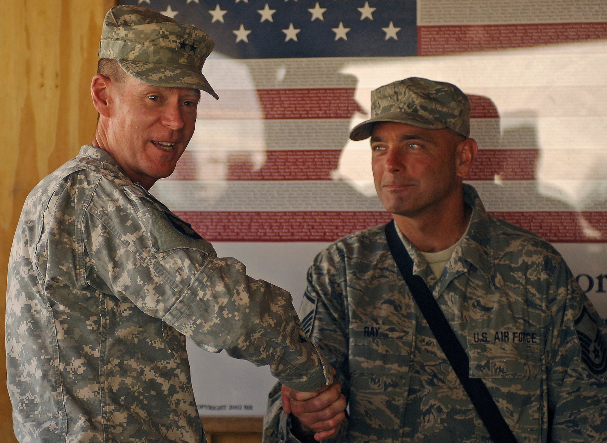 BAGRAM AIR FIELD, Afghanistan -- Army Maj. Gen. Jeffrey Schloesser, International Security Assistance Force Regional Commander East and senior leader at Bagram Air Field, thanks Master Sgt. Robert Ray and 455th Air Expeditionary Wing Airmen for their contributions during his tenure here. The two-star general, who plans to return home soon, recognized the efforts of Sergeant Ray, a C-130 communication and navigation system technician, and nine other Airmen, and presented them with his honorary military coin. The Airmen of the 455th AEW provide close air support and combat search and rescue capabilities for coalition ground troops in addition to aeromedical evacuations, perimeter defense and expertise in a variety of specialized jobs throughout the theater of operations. (Air Force/Staff Sgt. Jason Lake)