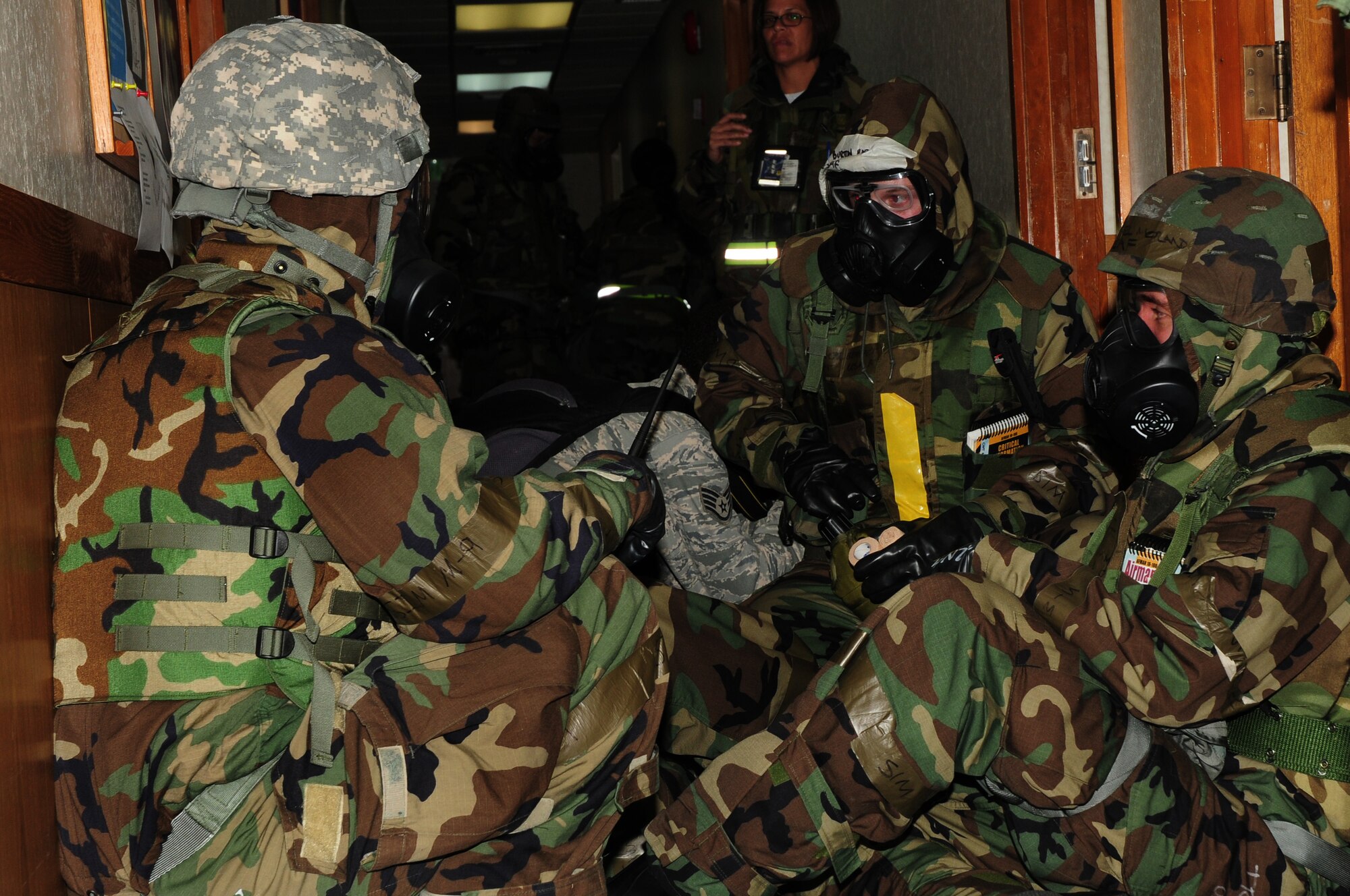 Kadena Airman currently deployed to 'Base X' don their MOPP 4 gear and perform buddy checks during Beverly High 09-2 Local Operational Readiness Exercise May 13. The LORE tests base personnel on their combat readiness for real world emergency/combat events. (U.S. Air Force photo/Airman 1st Class Amanda Grabiec)