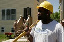 Windy City Habitat for Humanity volunteer group supervisor, Leon Metcalf overlooks the project with volunteers from 1st Marine Division, Marine Air Control Group 48, and 2nd Battalion, 24th Marines based in Chicago as part of a volunteer project during Marine Week Chicago.::r::::n::
