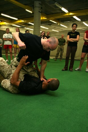 Sgt. Joshua P. Ott, 24, martial arts instructor trainer, based out of Quantico, Va., portrays an assailant, while Sgt. Shurron D. Thompson, 23, explains what course of action to take in the situation. Marines from the Martial Arts Center of Excellence gave three sororities from the University of Chicago a self defense class May 14.