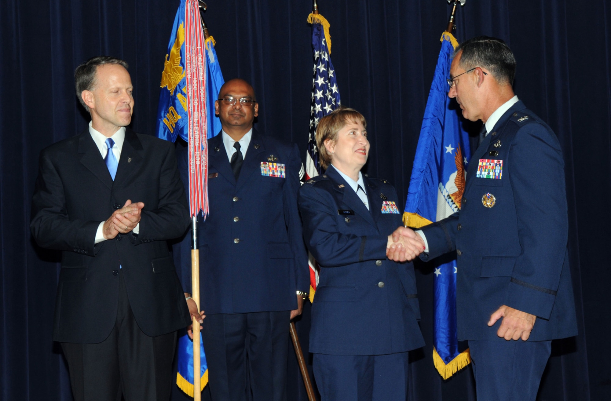 Col. Frederic Ryder (right) congratulates Col. Sandra Adams, the Air Force Services Agency's new commander, after a change-of-command ceremony May 12 at Randolph Air Force Base, Texas.  Colonel Adams succeeded Colonel Ryder who was honored in a retirement ceremony earlier that day.  The change of command, which featured performances by Tops in Blue vocalists, included remarks by Charles Milam (left), Air Force Services director. (U.S. Air Force photo/Joel Martinez) 
