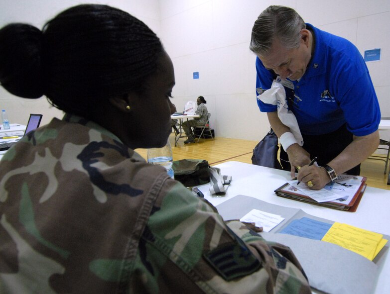 Staff Sgt. Lichella Emmanuel, 8th Communications Squadron, helps to out process Werner Klauck during the non-combatant evacuation operation Courageous Channel 09-01 at Kunsan Air Base, Republic of Korea, May 15. The NEO exercise tests the 8th Fighter Wing's, along with the rest of U.S. Forces in Korea’s, capabilities to evacuate non-combatants from the country. (U.S. Air Force Photo/Senior Airman Gustavo Gonzalez)