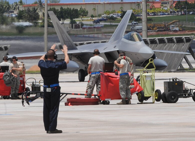 ANDERSEN AIR FORCE BASE, Guam – A 525th Expeditionary Fighter Squadron Airman helps direct an F-22A Raptor to its final parking position after a nine-hour flight from the squadron’s home station at Elmendorf Air Force Base, Alaska. The Raptors from the 5-2-5 are deployed in support of Pacific Command’s Theatre Support Package. (U.S. Air Force photo by Christopher Bush) 