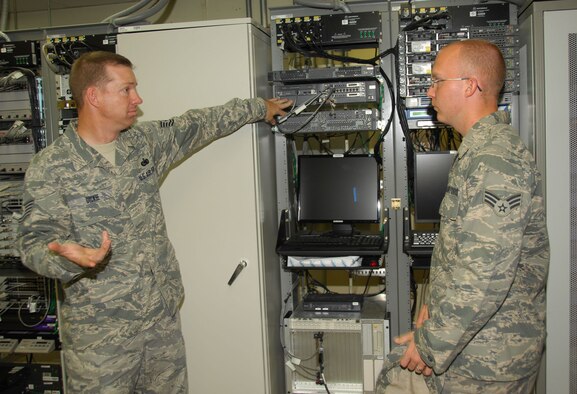 ANDERSEN AIR FORCE BASE, Guam - Tech. Sgt. Curtis Dickie, 36th Communications Squadron noncommissioned officer in charge of transmission systems, discusses the functions of a land mobile radio trunking system to Senior Airman Daniel Letchworth, who is deployed here from Goodfellow Air Force Base, Texas. Sergeant Dickie's dedication to the mission garnered him recognition as this week's 'Top Performer.' (U.S. Air Force photo by Senior Airman Shane Dunaway)