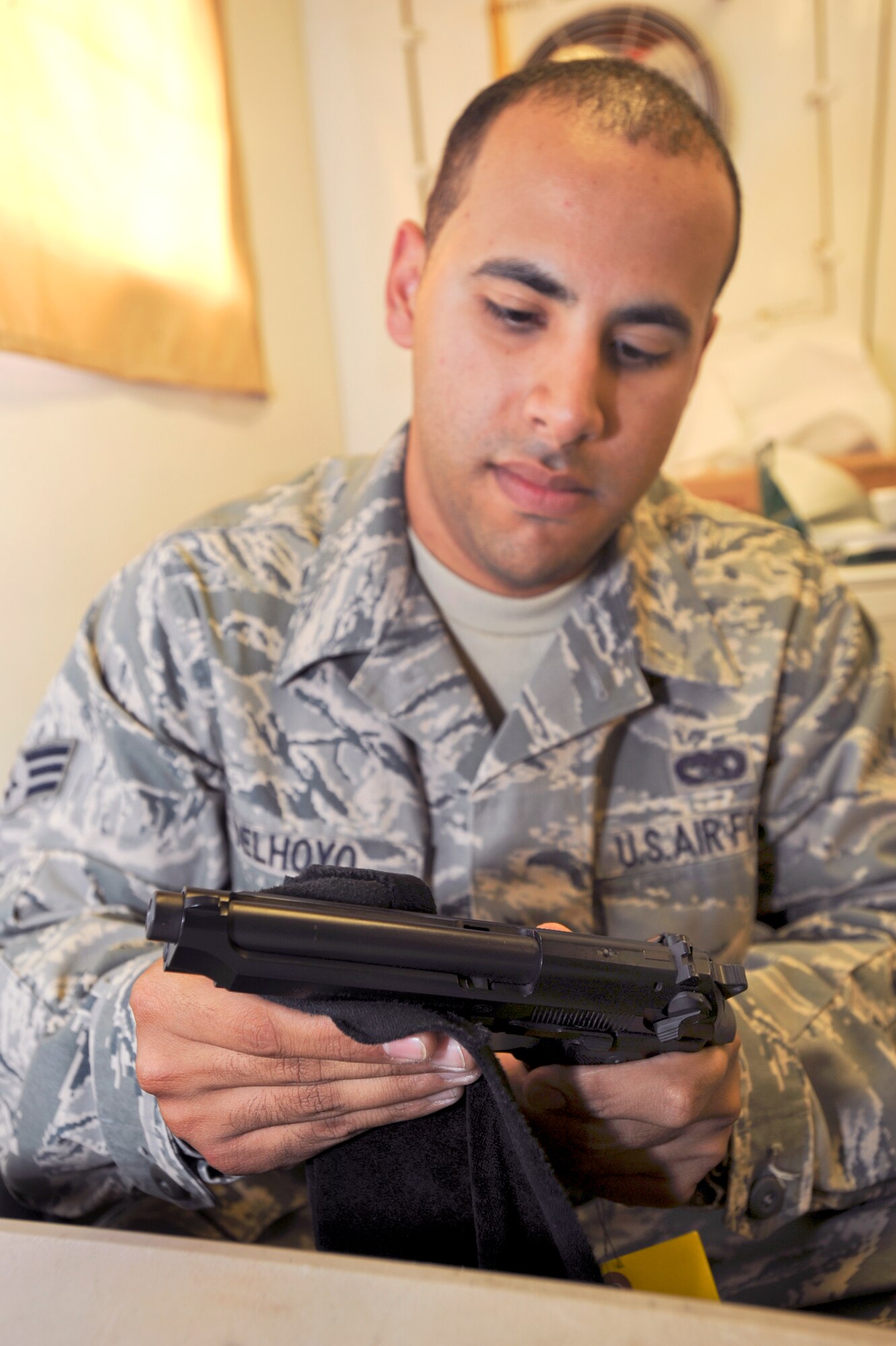 Senior Airman Osvaldo Delhoyo, a supply journeyman for the 379th Logistic Readiness Squadron, cleans a 9mm pistol at the armory here, May 14, 2009, in an undisclosed location in Southwest Asia.  Airman Delhoyo and fellow armory personnel maintain the safekeeping of all the weapons for transient personnel while they are staying on base.  Airman Delhoyo is native to Lawrence, Mass. and is deployed from Tyndall Air Force Base, Fla., in support of Operations Iraqi and Enduring Freedom and Combined Joint Task Force - Horn of Africa. (U.S. Air Force Photo by Staff Sgt. Joshua Garcia/released)