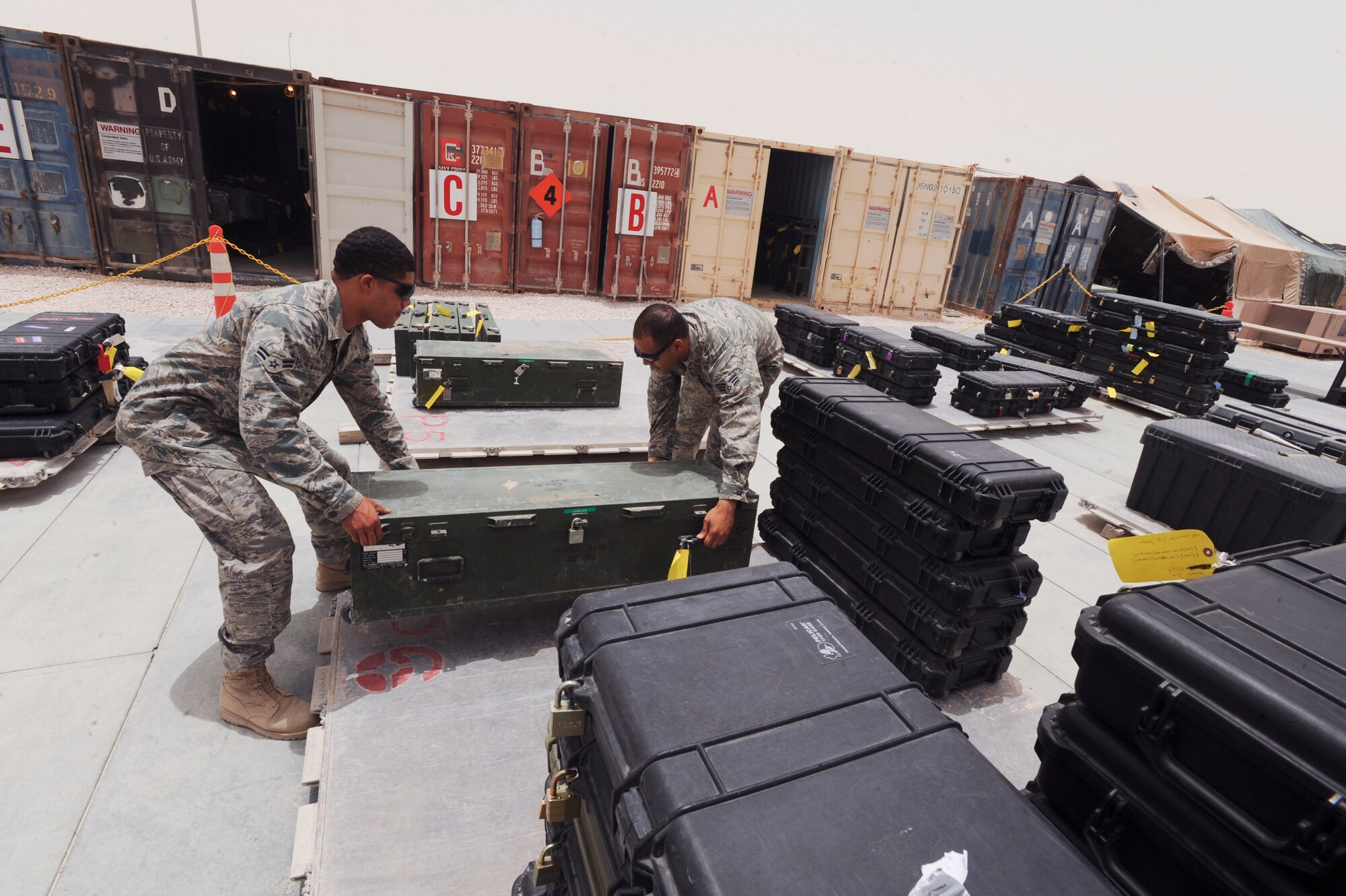 Airman 1st Class Jonathan Kelley and Senior Airman Osvaldo Delhoyo, both supply journeymen for the 379th Logistic Readiness Squadron, organize the armory area here, May 14, 2009, in an undisclosed location in Southwest Asia. Armory personnel will handle up to 20,000 weapons belonging to transient personnel in addition to the base weaponry as well. Airman Kelley is native to Crenshaw, Calif. and is deployed from Ellsworth Air Force Base, S.D. while Airman Delhoyo hails from Lawrence, Mass. and is deployed from Tyndell Air Force Base Fla., both in support of Operations Iraqi and Enduring Freedom and Combined Joint Task Force - Horn of Africa. (U.S. Air Force Photo by Staff Sgt. Joshua Garcia/released)