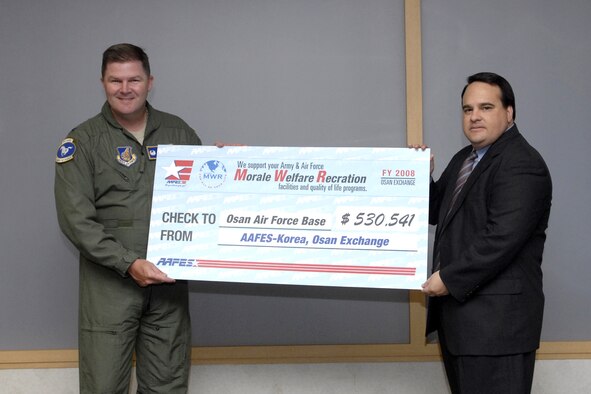 Col. Thomas Deale accepts a morale, welfare and recreation dividend check from Mr. Steve Pena of AAFES-Korea in the amount of $530,541 May 12. Colonel Deale is the 51st Fighter Wing commander. U.S. Air Force Photo/Staff Sgt. Brian Ferguson)