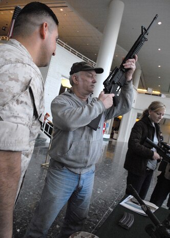Tom Schaefer, a native of Arlington Heights, Ill., looks at the M16A4 service rifle as Staff Sgt. Javier Delatorre, platoon sargeant, 2nd Battalion 24th Marines, Chicago, explains the properties of the weapon at Arlington Park, Arlington Heights, Ill., May 15. There was a weapons and vehicle display as well as the Marine Corps Air Ground Combat Center Twenty-Nine Palms Jazz Ensemble.