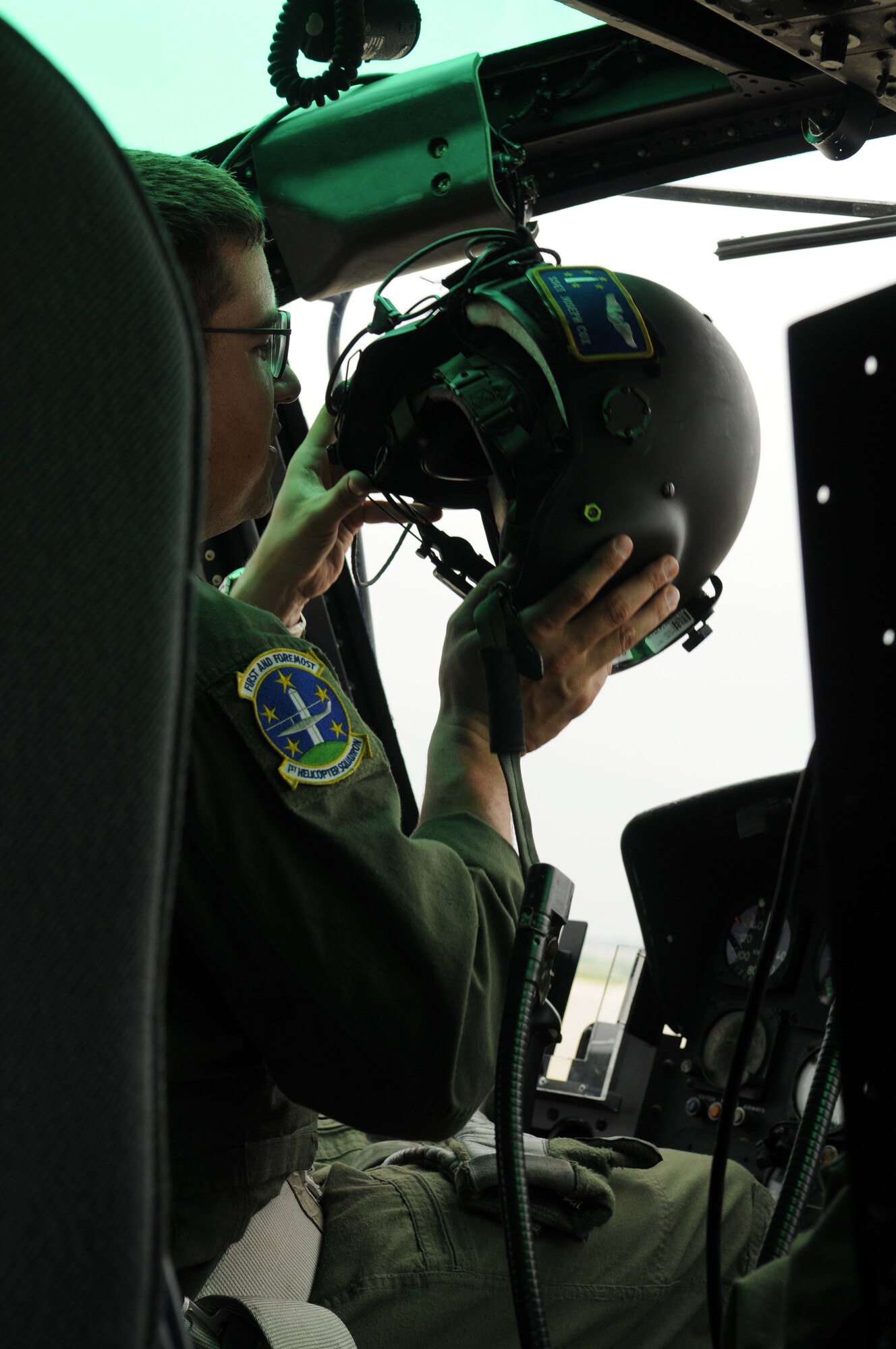 Staff Sgt. Joseph Cox, 1st Helicopter Squadron, puts on his helmet after performing routine checks before takeoff during the Joint Service Open House May 16 at Andrews Air Force Base, Md. JSOH celebrates military history while showcasing the future capabilities of the world's finest military force. (U.S. Air Force photo by Senior Airman Marleah Miller)