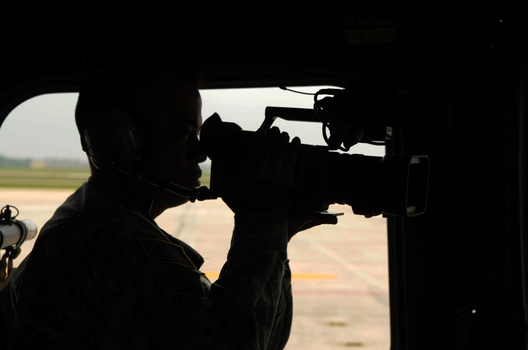 U.S. Army Staff Sgt.Walter Talens, 302nd Mobile Public Affairs Detachment, films pilots from the 1st Helicopter Squadron during the Joint Service Open House May 16 at Andrews Air Force Base, Md. JSOH celebrates military history while showcasing the future capabilities of the world's finest military force. (U.S. Air Force photo by Senior Airman Marleah Miller)