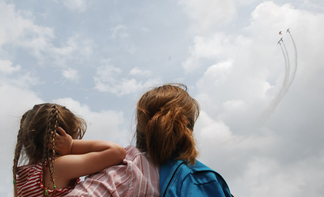 Cassie Hambelton and daughter Heidi watch The Collaborators, four high-performance aerobatic airplanes, during the Joint Service Open House May 15  at Andrews AFB, Md. JSOH offers an opportunity for service members to meet and thank the public for their support and to showcase America's skilled military. (U.S Air Force photo by Senior Airman Alexandre Montes)
