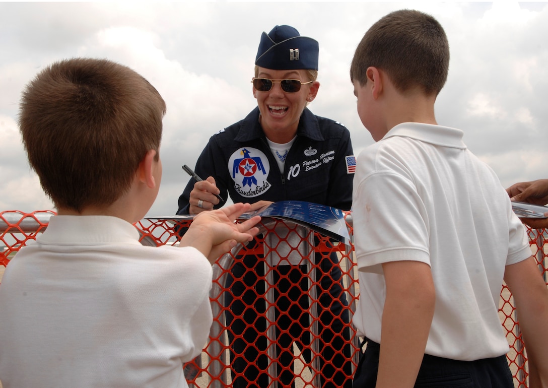 Capt. Patrina Hanson, U.S. Air Force Thunderbirds executive officer, signs autographs for Sebastian Greenberg and Jonathan Greenway May 15 during the Joint Service Open House on Andrews AFB, Md. The JSOH offers an opportunity for service members to meet and thank the public for their support while showcasing  America’s skilled military. (U.S. Air Force photo by Senior Airman Tim Chacon)