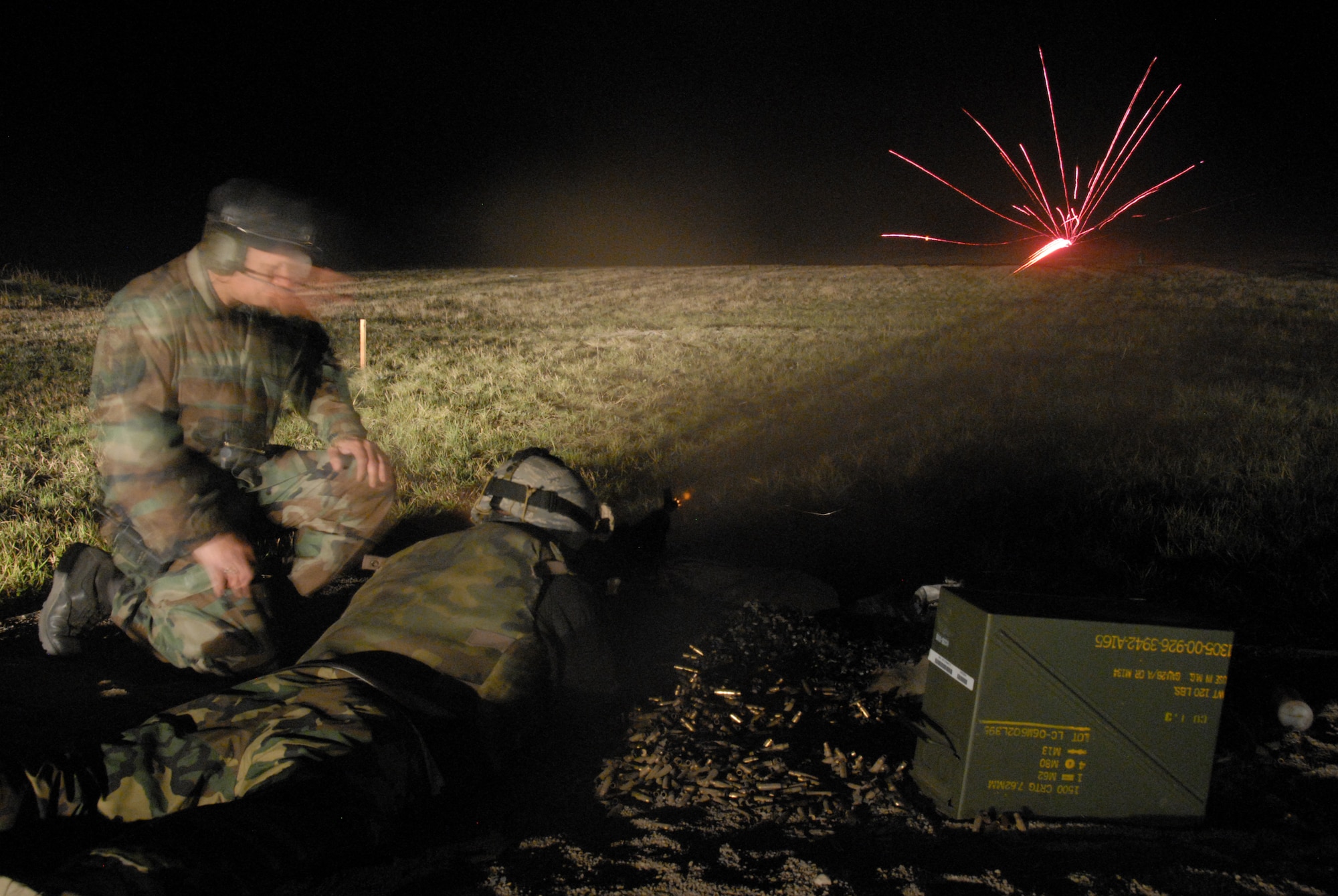 Under the illumination of flares, Security Forces from the 185th Air Refueling Wing, Sioux City, Iowa operate the M-240 and M-249 machineguns during night fire qualification at Fort Harrison, Montana on 13 May 2009.  Tracer rounds aide gunners by allowing him or her to “walk” the fire onto the pop up targets. (US photo by TSgt Brian Cox)