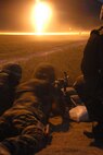 Under the illumination of flares, Security Forces from the 185th Air Refueling Wing, Sioux City, Iowa operate the M-240 and M-249 machineguns during night fire qualification at Fort Harrison, Montana on 13 May 2009.  Tracer rounds aide gunners by allowing him or her to “walk” the fire onto the pop up targets. (US photo by TSgt Brian Cox)