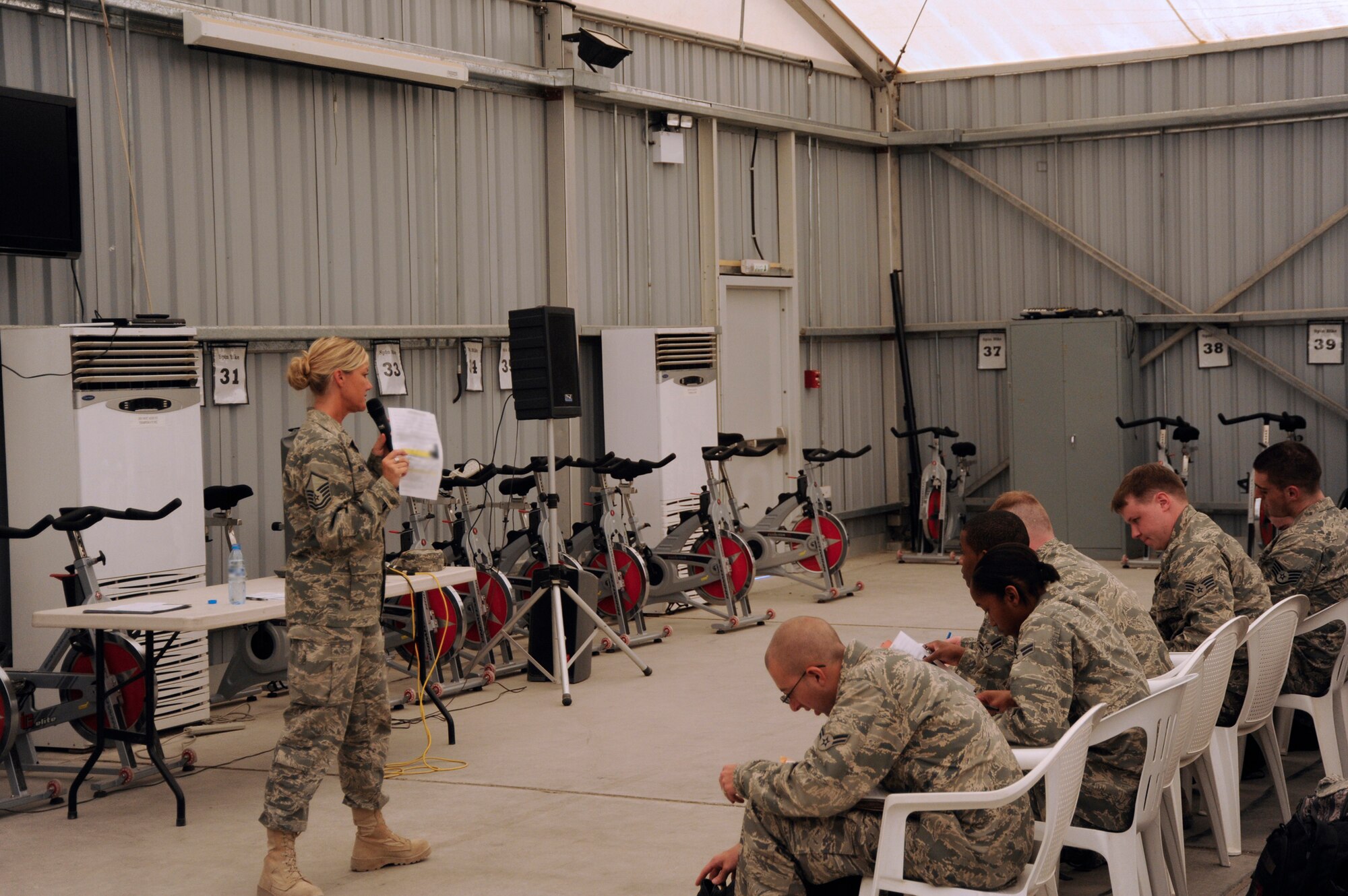 SOUTHWEST ASIA -- Master Sgt. Stephanie Kerekes, 380th Expeditionary Force Support Squadron Personnel Support for Contingency Operations flight superintendent, briefs newly arrived Airmen here recently. Preparing for new Airmen to rotate in begins several months and advance and culminates with a flawless processing line. This enables Airmen to get on the ground quickly and accomplish the tasking order as efficiently as possible. (U.S. Air Force photo by Staff Sgt. Mike Andriacco) (Released)