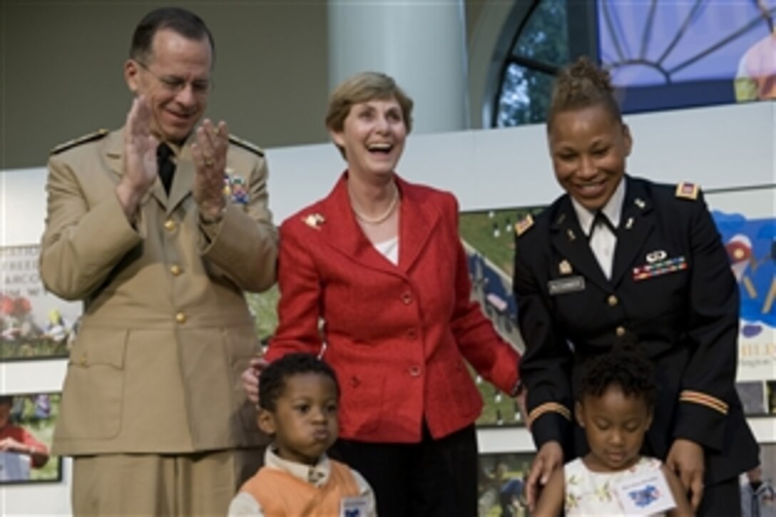 Navy Adm. Mike Mullen, chairman of the Joint Chiefs of Staff, and his wife Deborah, center, present commemorative books "For Children of Valor" to U.S. Army Capt. Marissa Alexander and her twin children Avery and Alaya at Arlington National Cemetery, Va., May 15, 2009. The book is to assist children affected by loss of a close loved one to understand and process their grief.