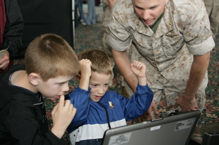 Andrew McPherson, 6, celebrates his success on the Deployable Virtual Training Environment System at Navy Pier May 15. The O'Fallon, Ill., native was acting as a pilot of the AH-1 W Super Cobra helicopter, and was taking aim on ground targets. The pier held host to numerous Marine Corps gear and weapon displays as a part of the first ever Marine Week.The displays are free and open to the public. The gear and weapons will be set-up in Festival Hall through Sunday evening.